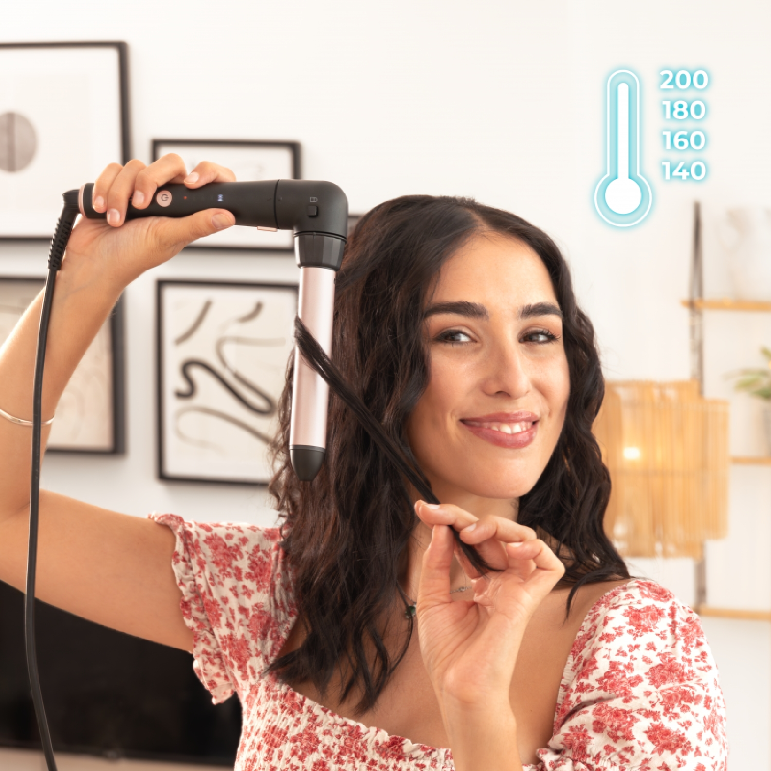 Donna che si arriccia i capelli con un ferro arricciacapelli, mostrando le impostazioni di temperatura. Interno.
