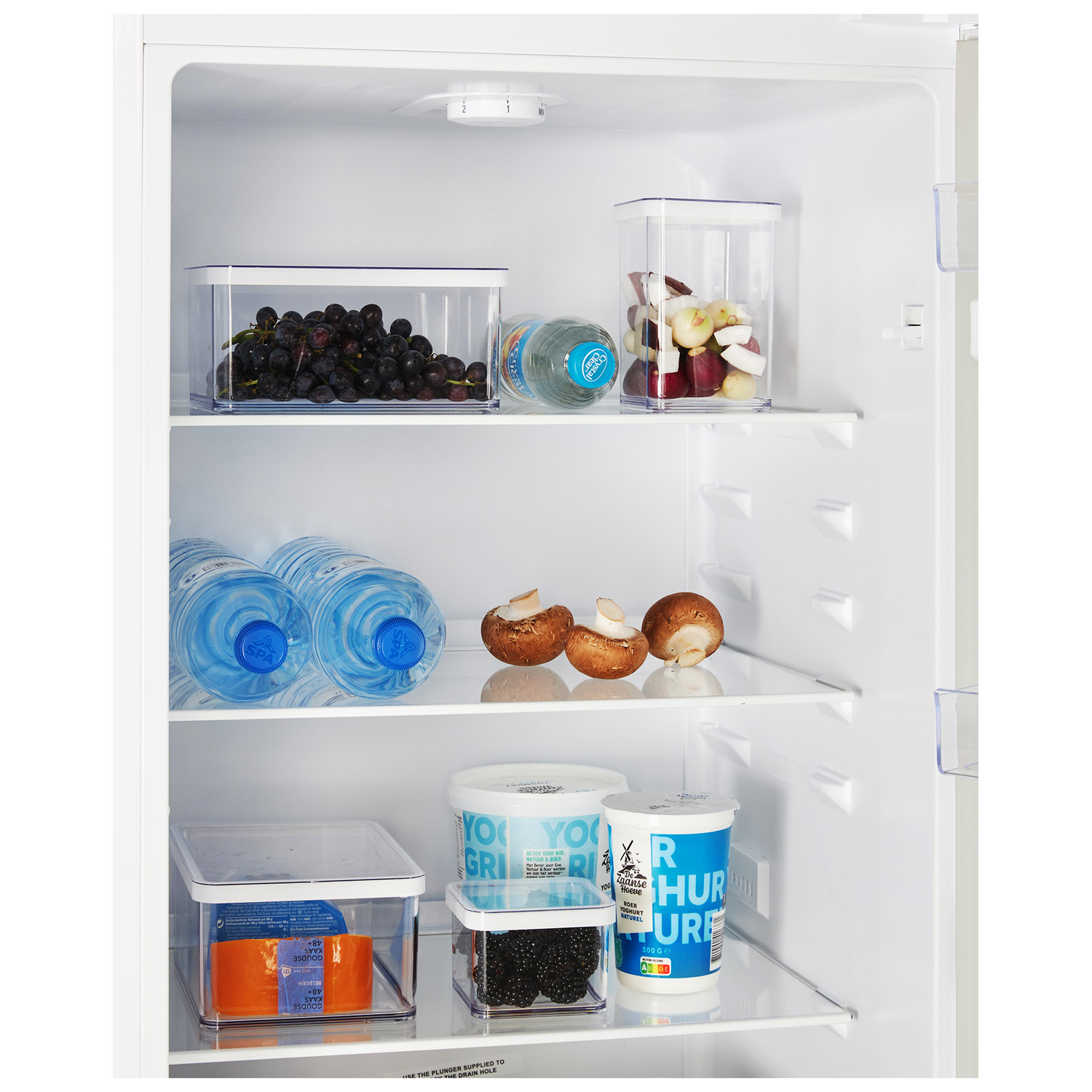 Interno di un frigorifero con ripiani. Sono visibili frutta, bottiglie d'acqua e contenitori di cibo.