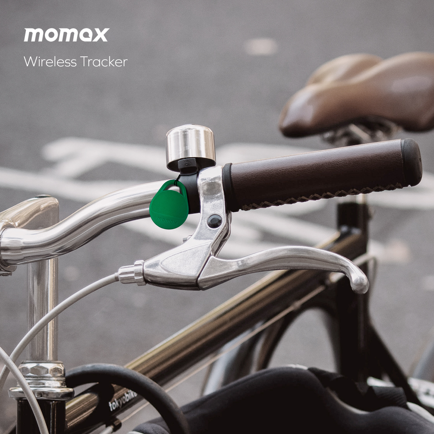 A green tracker attached to a bicycle handlebar, next to the brake lever.