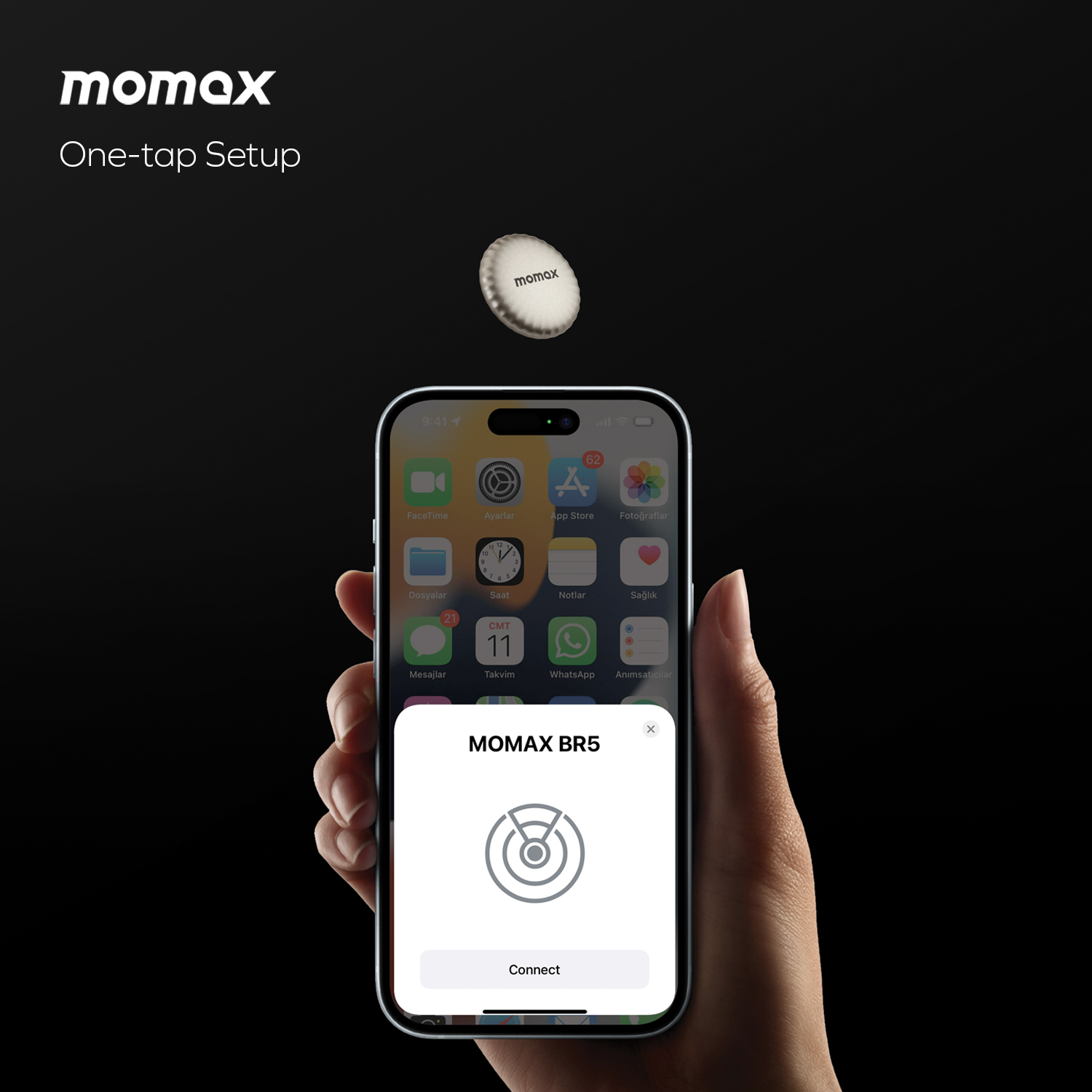 Hand holding phone with Momax tracker setup screen. The tracker is white.