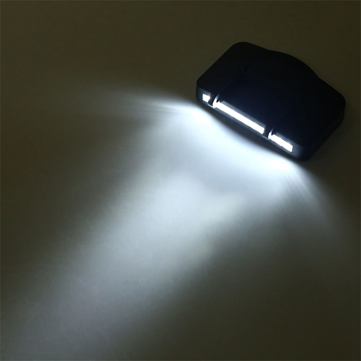 Schwarzes Licht mit hellem weißen Strahl, der auf eine graue Oberfläche scheint. Draufsicht.