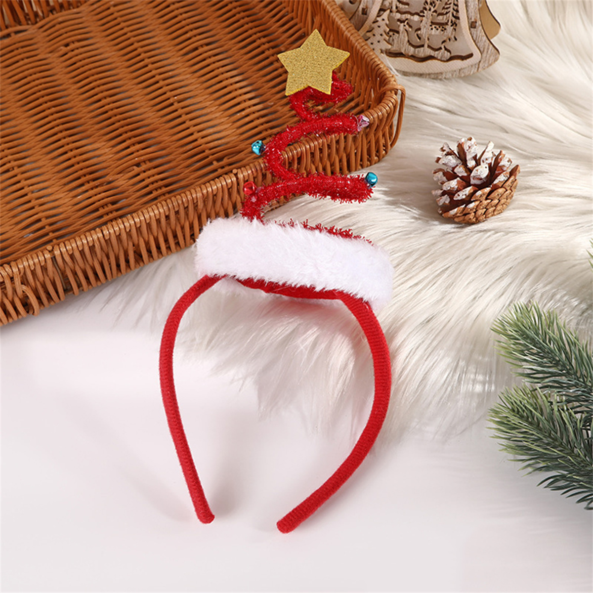Ein Weihnachts-Haarband mit roten Geweihen, einem goldenen Stern und einem weißen Fellrand liegt auf einer weißen Oberfläche.
