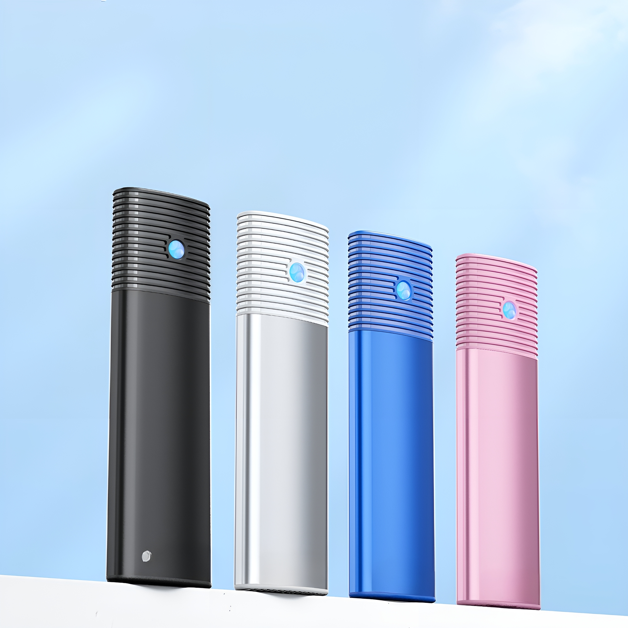 Vier rechteckige Powerbanks in verschiedenen Farben (Schwarz, Silber, Blau, Rosa) vor blauem Himmel.