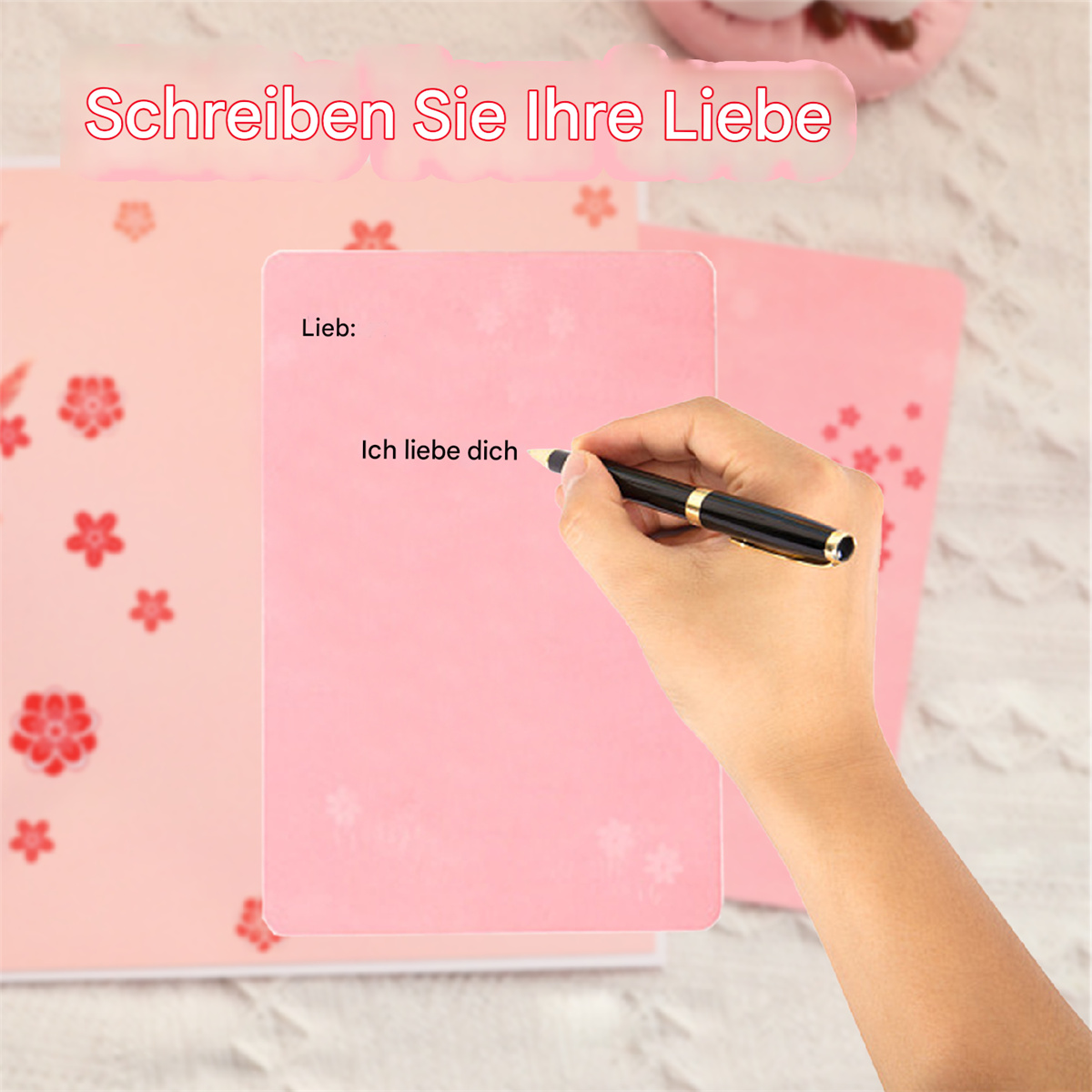 Eine Person schreibt 'Ich liebe dich' auf rosa Papier mit einem Stift.