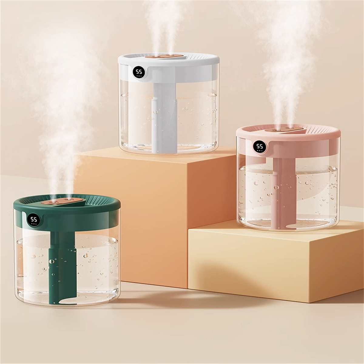 Drei Luftbefeuchter mit Wasserdampf, weiß, grün und pink, auf beige und orangen Blöcken.