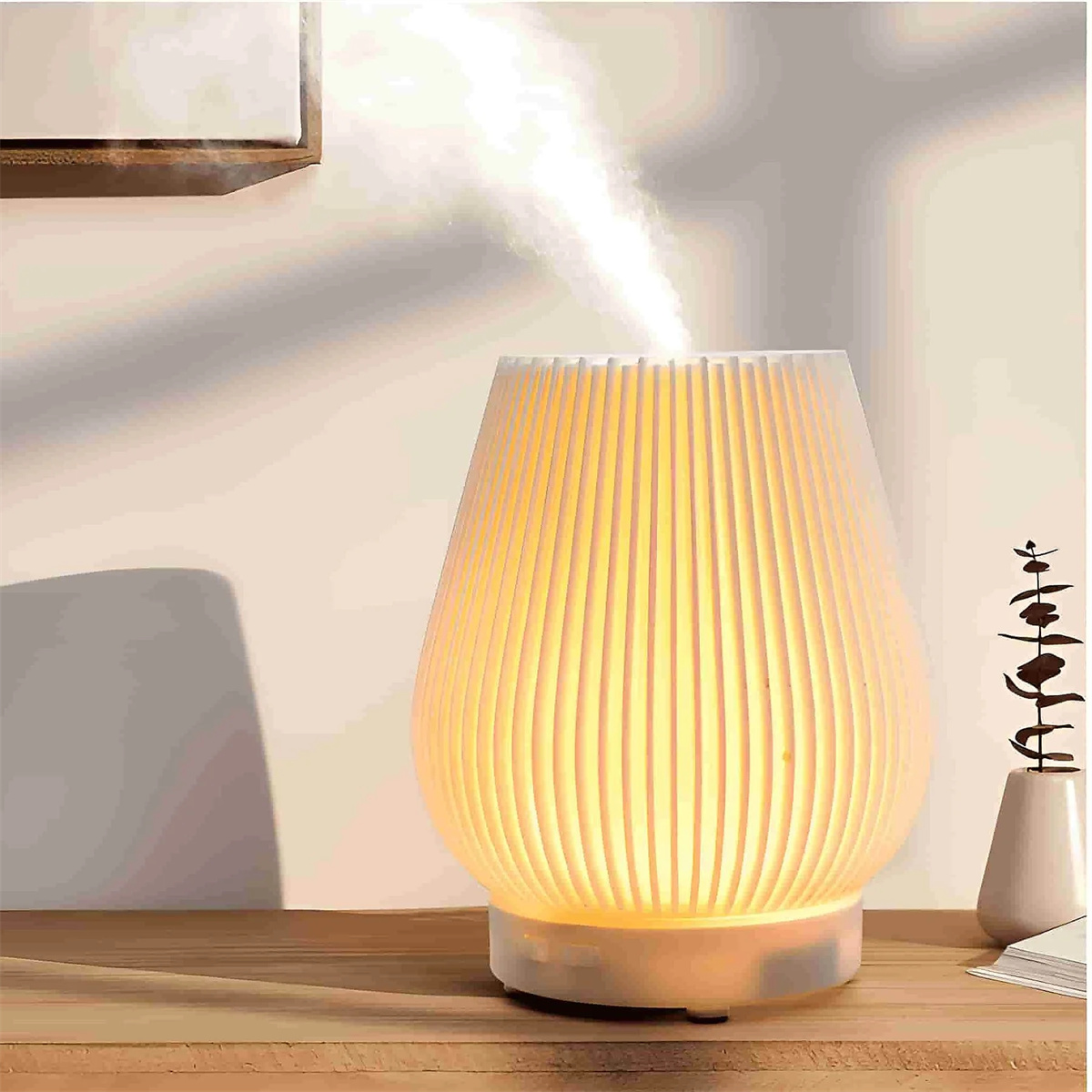 Weißer Diffusor mit Licht. Holztisch und Pflanze rechts.