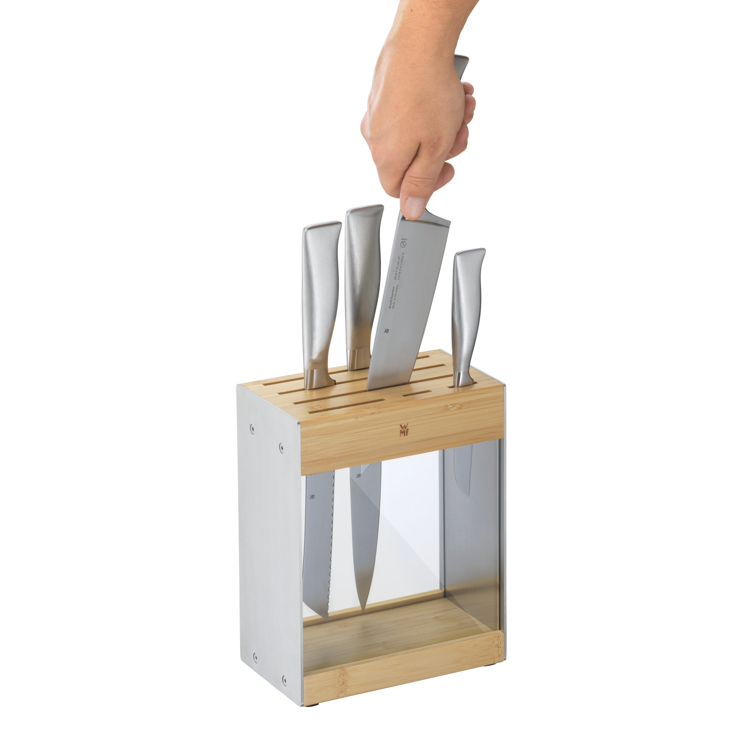 Eine Hand, die ein Messer in einen Messerblock legt. Andere Messer sind im Block. Weißer Hintergrund.