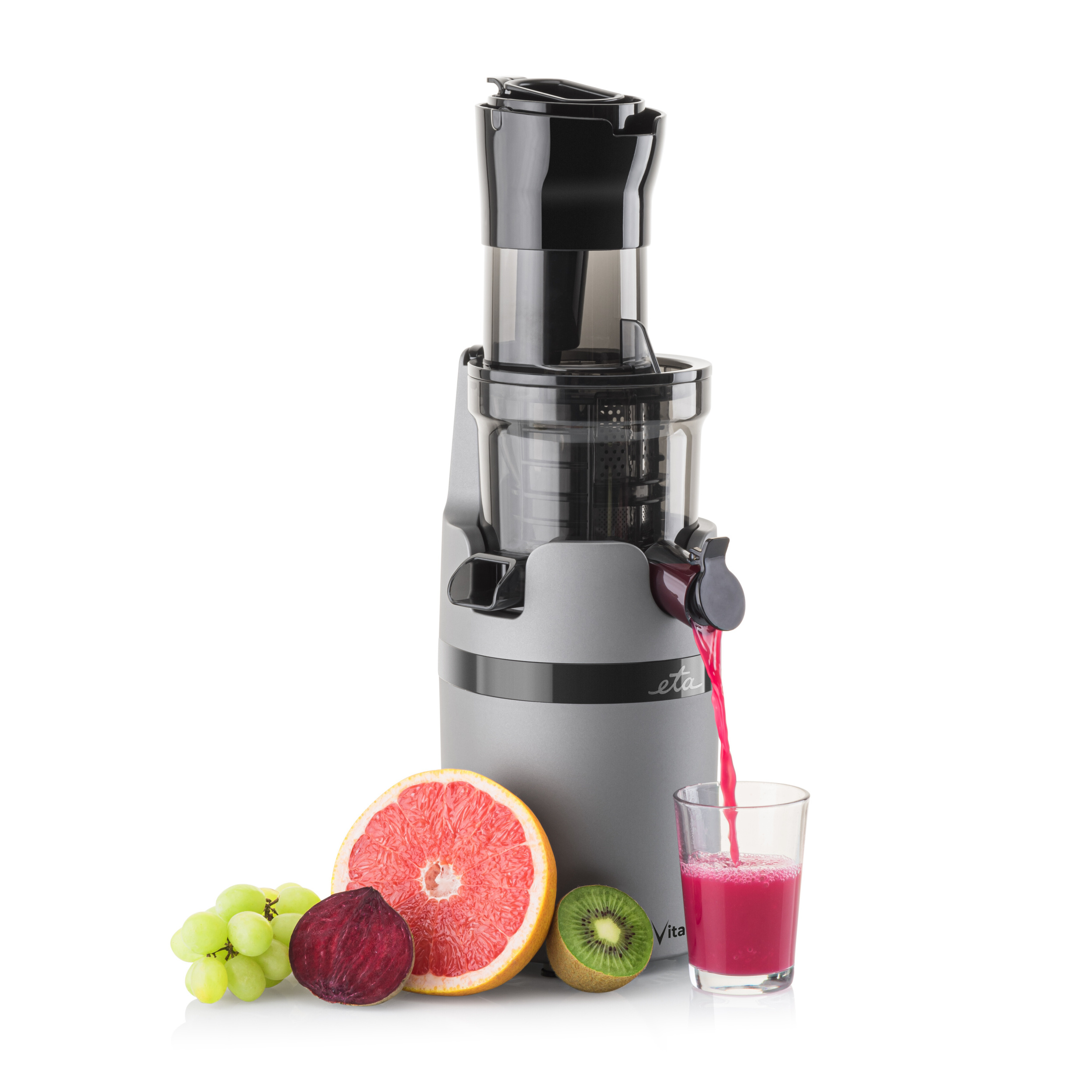 Entsafter mit Saft, der in ein Glas gegossen wird. Grapefruit, Kiwi, Trauben und Rote Bete.