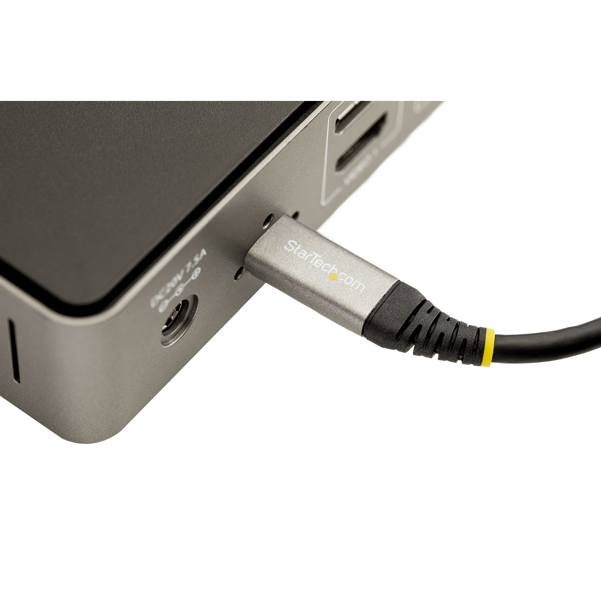 Cable USB-C plateado conectado a un dispositivo gris, sobre fondo blanco.