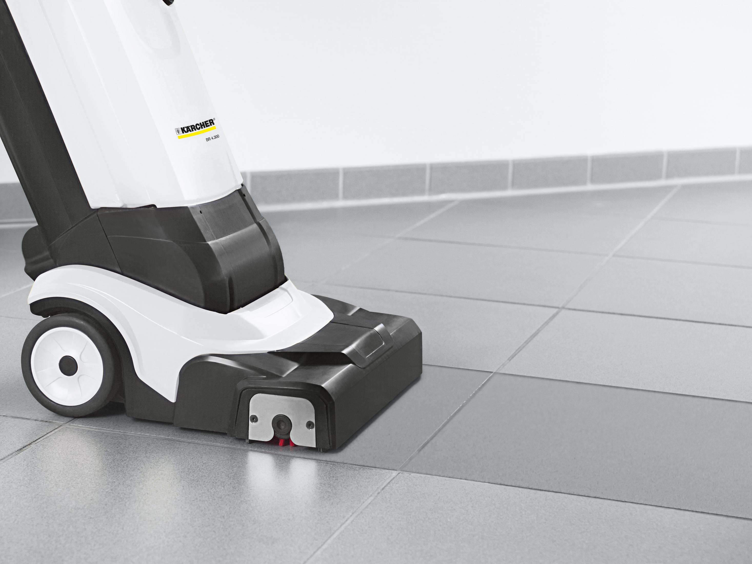 Zbliżenie biało-czarnej myjki do podłóg, z podłogą z płytek. Białe tło.