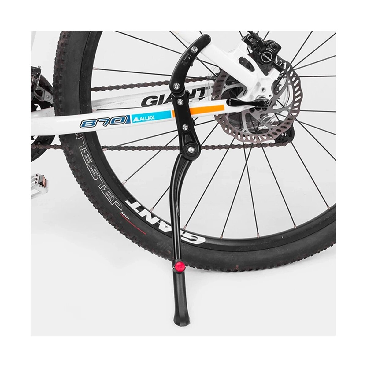 Koło rowerowe z zamontowaną podpórką. Podpórka jest czarna i ma czerwoną końcówkę.