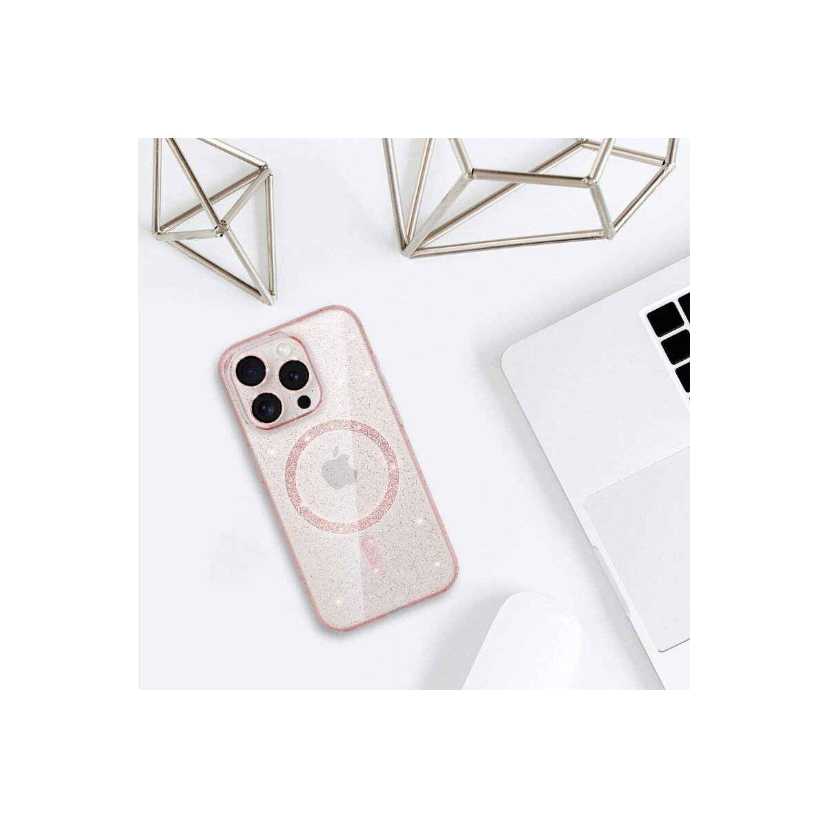 Custodia rosa per telefono con cerchio magsafe, laptop e forme metalliche decorative.