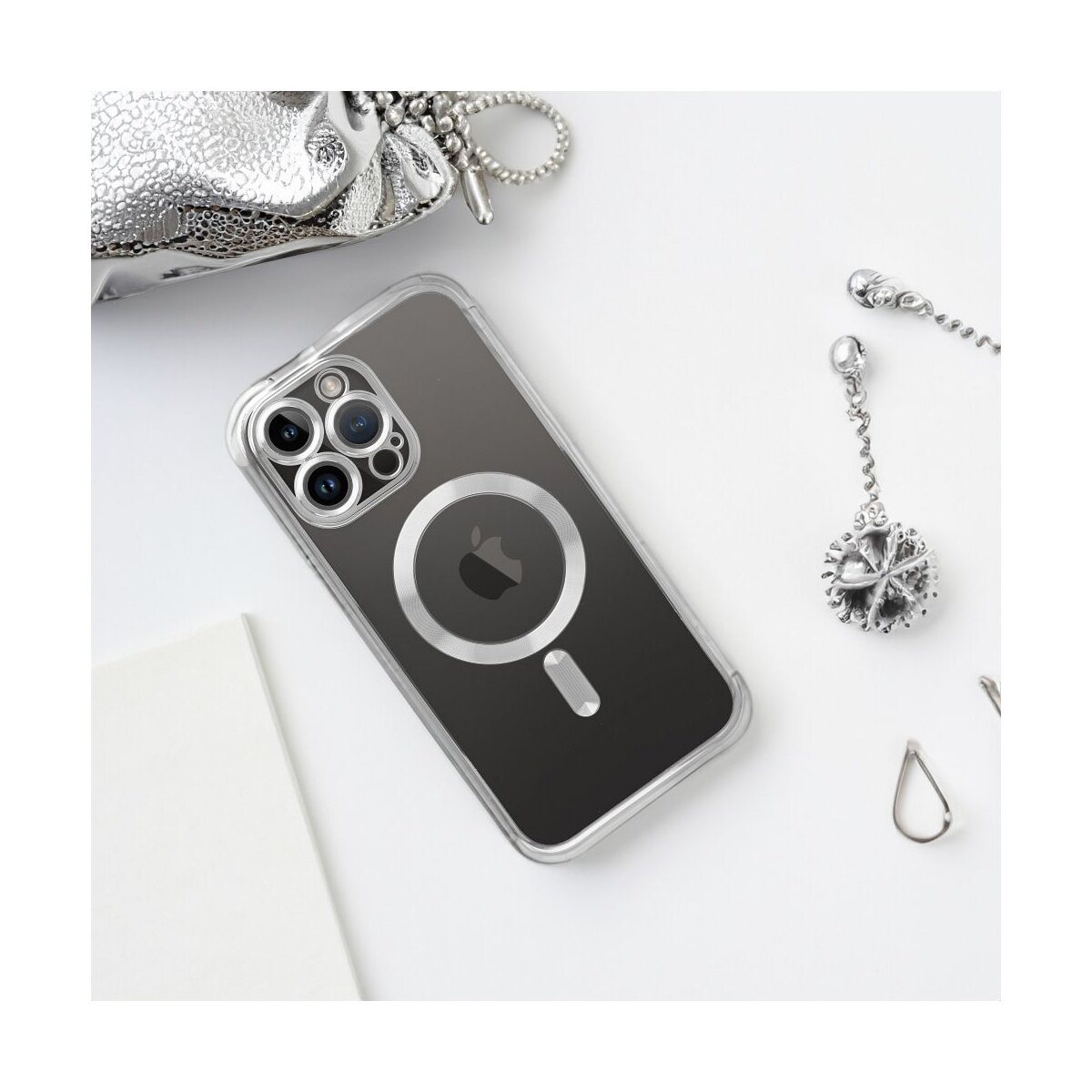 Transparente Handyhülle mit silberner Tasche und Anhänger auf weißem Untergrund. iPhone liegt in der Hülle.