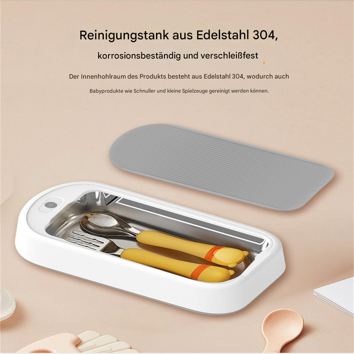 Weißer und stählerner Babyutensilienreiniger. Enthält einen Löffel, eine Gabel und einen grauen Deckel.
