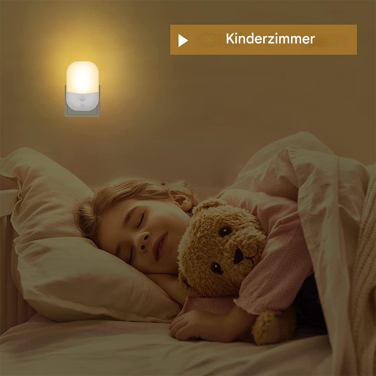 Ein Kind schläft im Bett, ein Nachtlicht an der Wand. Ein Teddybär ist in den Armen des Kindes.