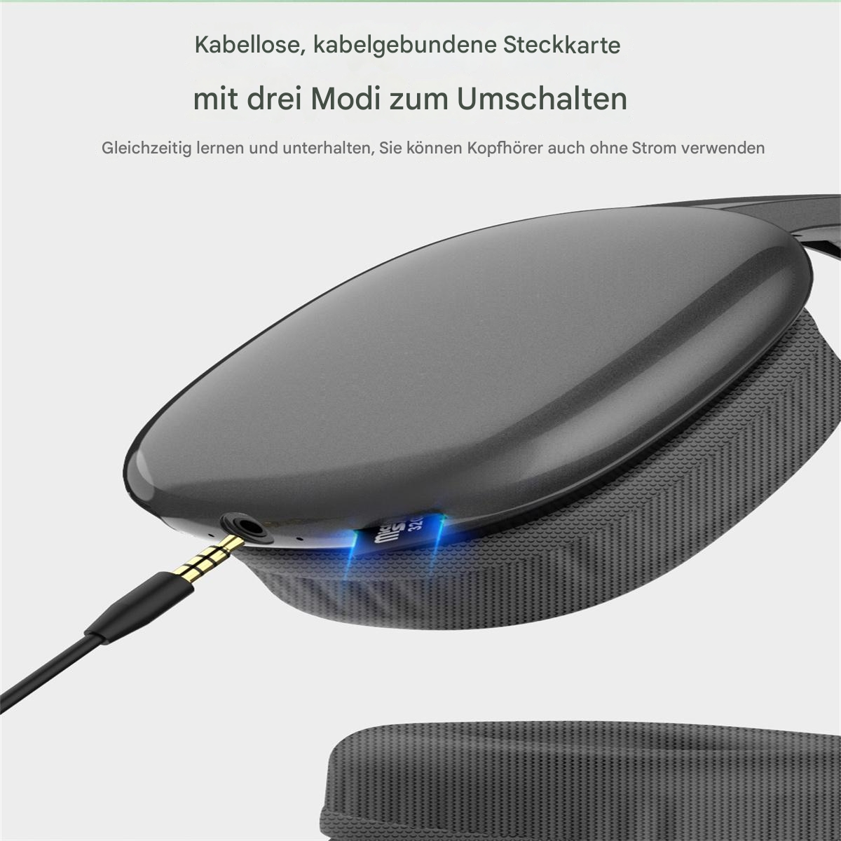 Graue Kopfhörer mit goldenem Stecker und Ladeanschluss, mit deutschem Text. Graue und schwarze Details.