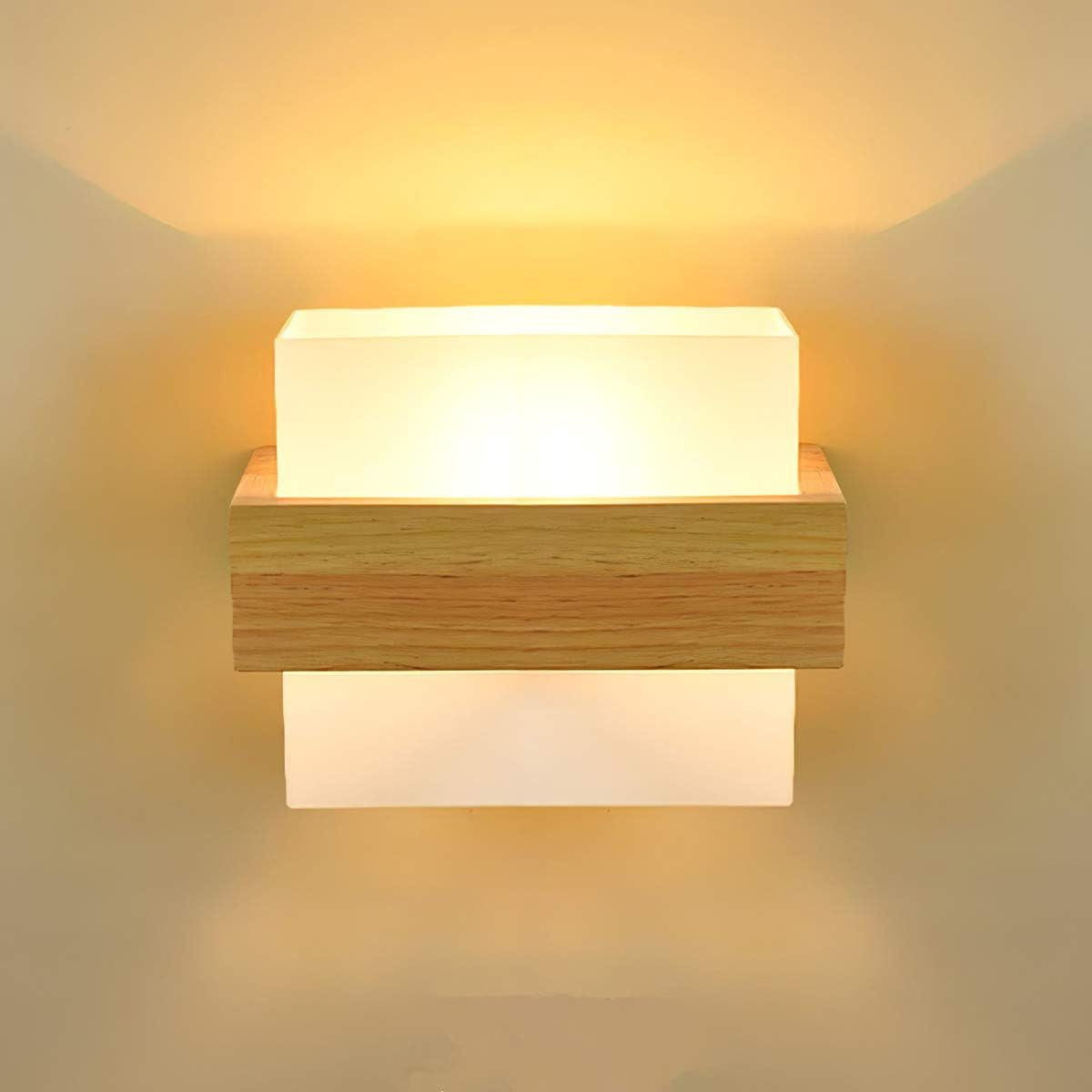 Eine Wandleuchte mit zwei weißen, mattierten Glasabschnitten, einem Holzrahmen und einem warmen, umgebenden Glühen.