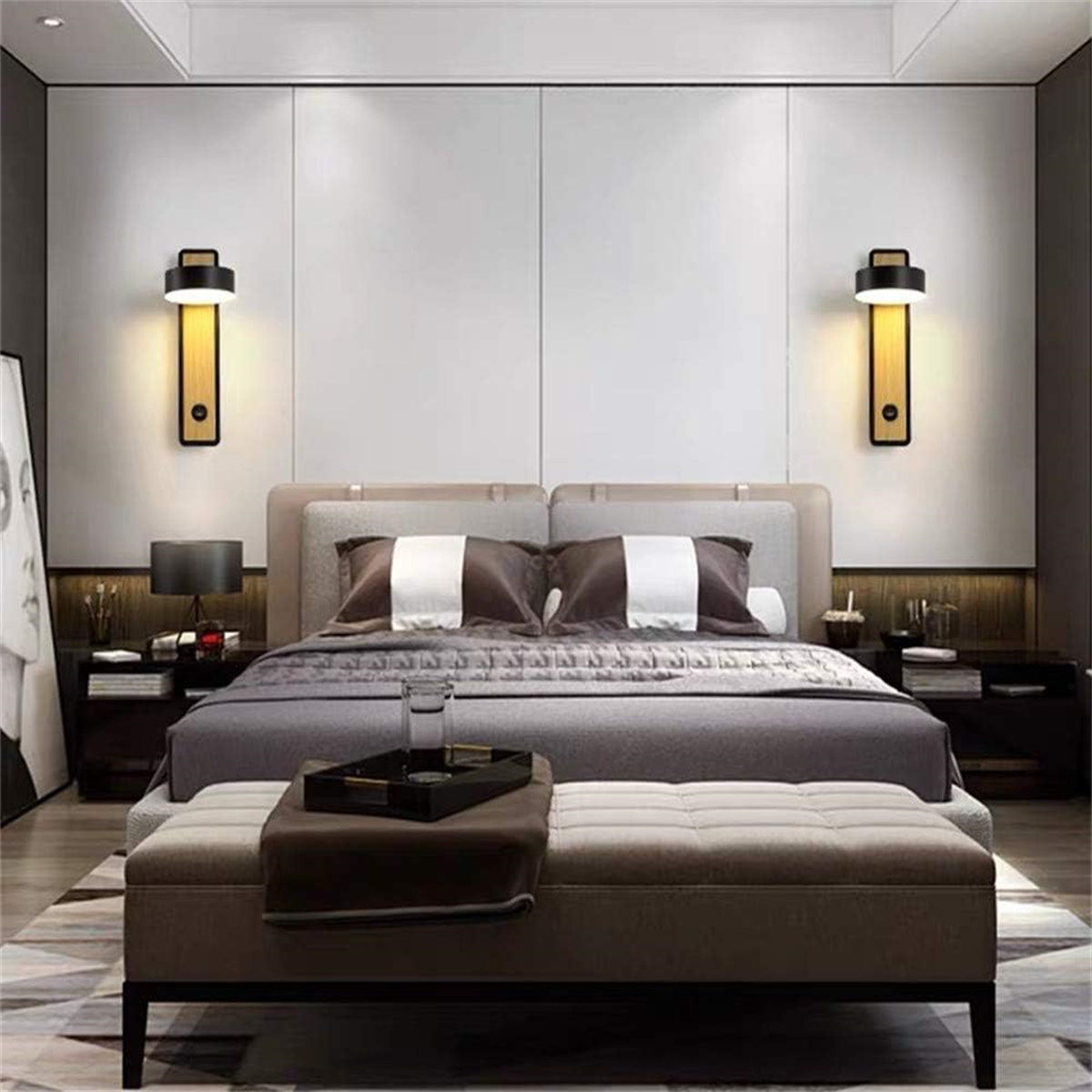 Schlafzimmer mit Bett, zwei Wandlampen, einer Bank und einem Tablett mit Gegenständen.