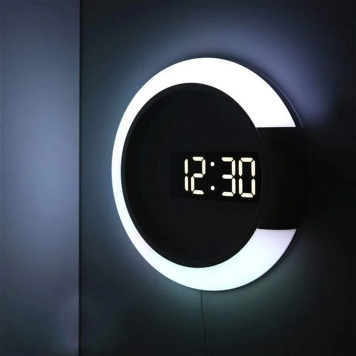Moderne Uhr an der Wand mit einem Ringlicht darum.