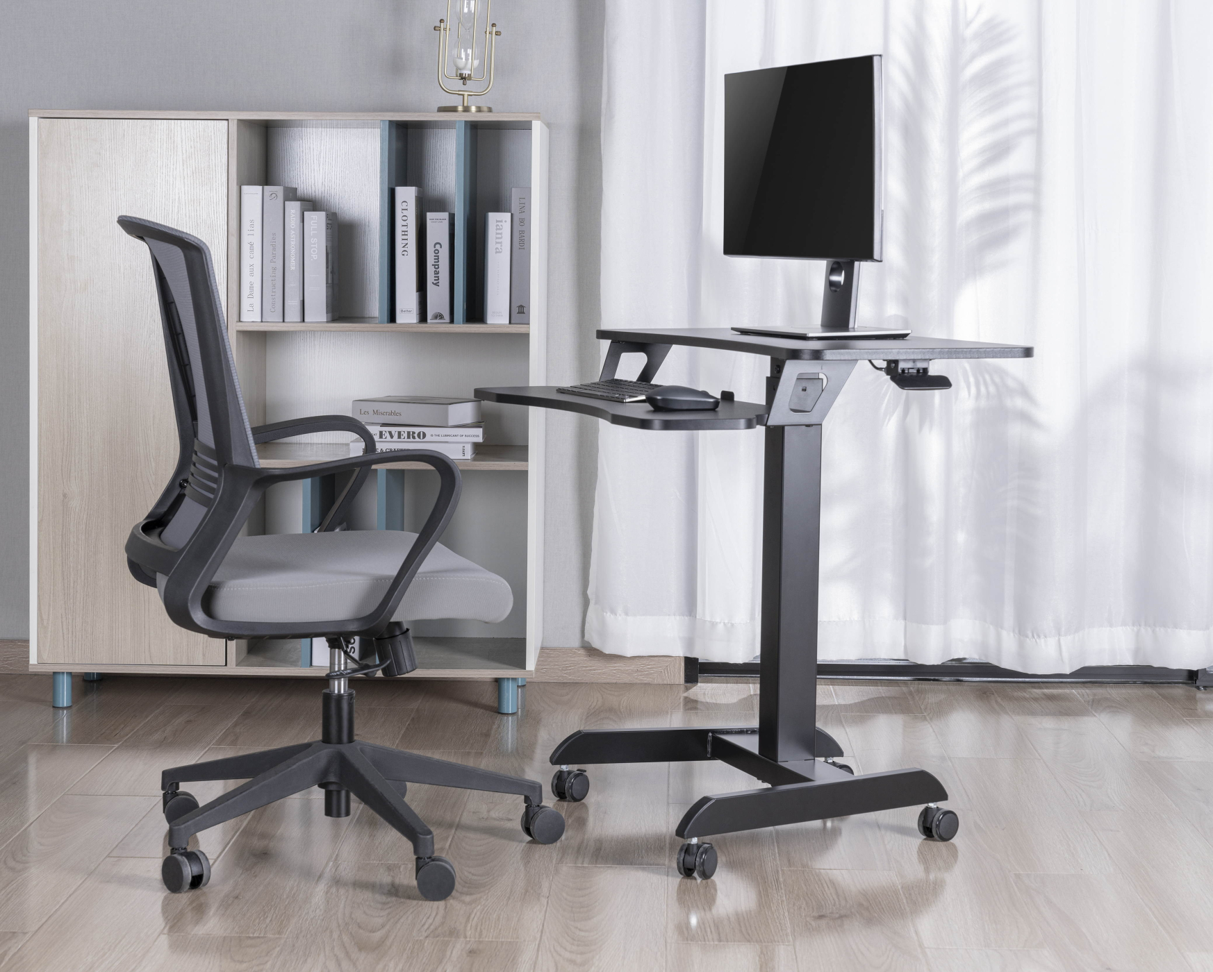 Kantooropstelling met een staande bureau, stoel, boekenplank en een monitor.