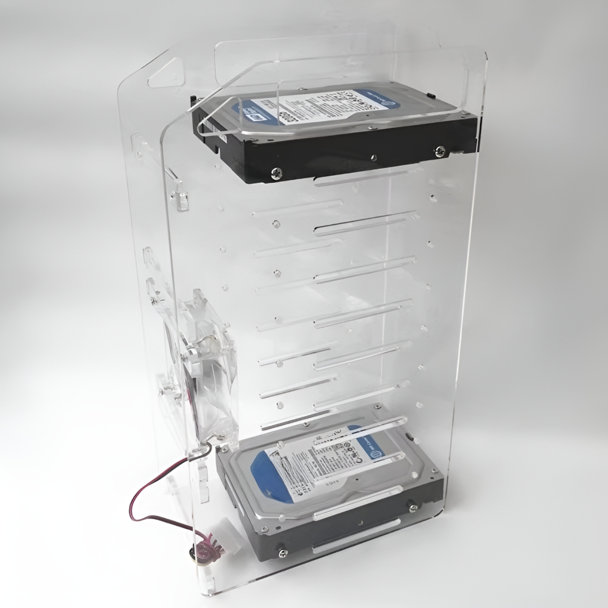 Ein durchsichtiges Acryl-Computergehäuse mit zwei Festplatten. Ein Lüfter ist sichtbar. Das Gehäuse steht auf weißem Grund.
