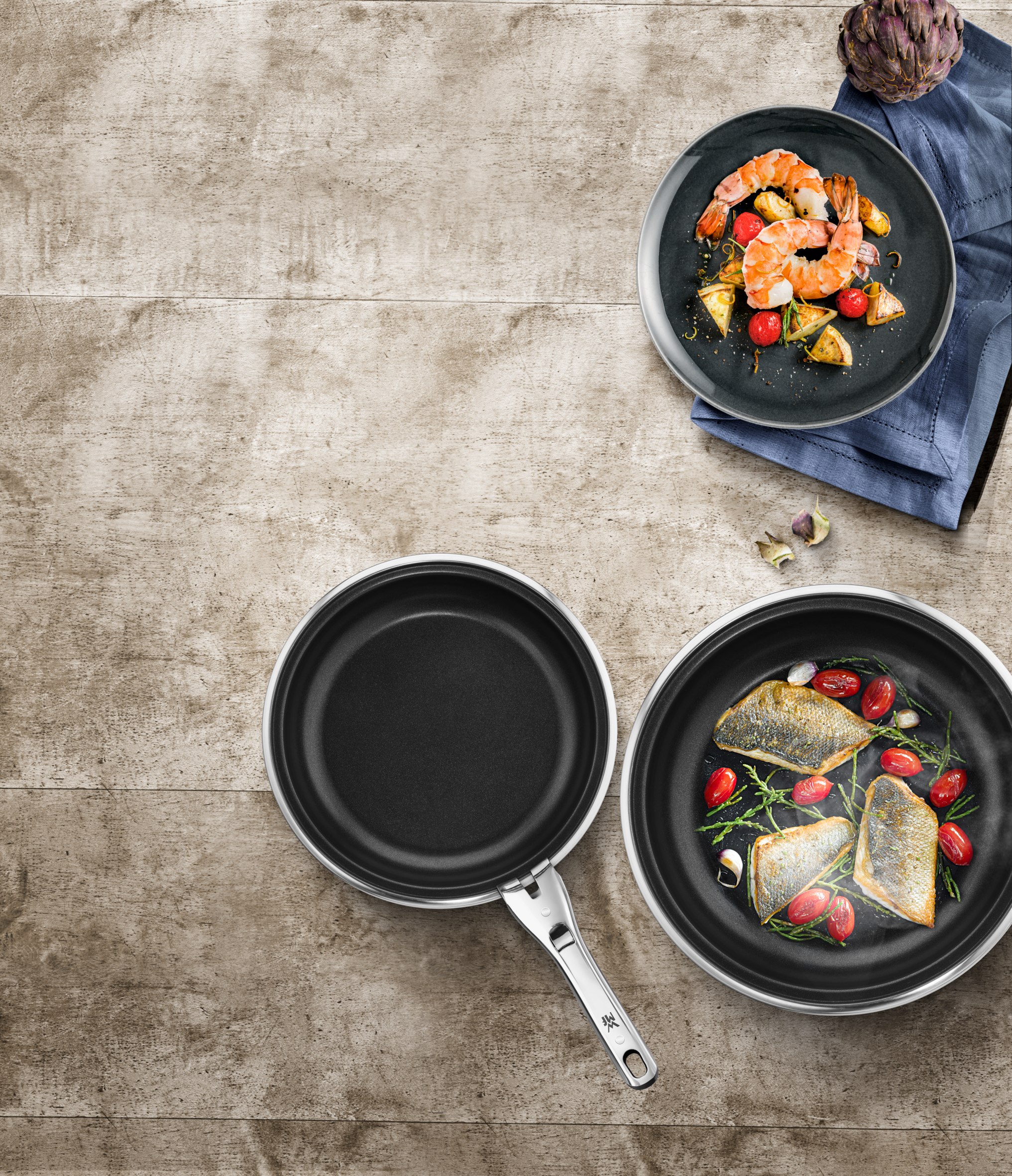 Gekochte Garnelen und Fisch in Pfannen auf einem Holztisch. Draufsicht.