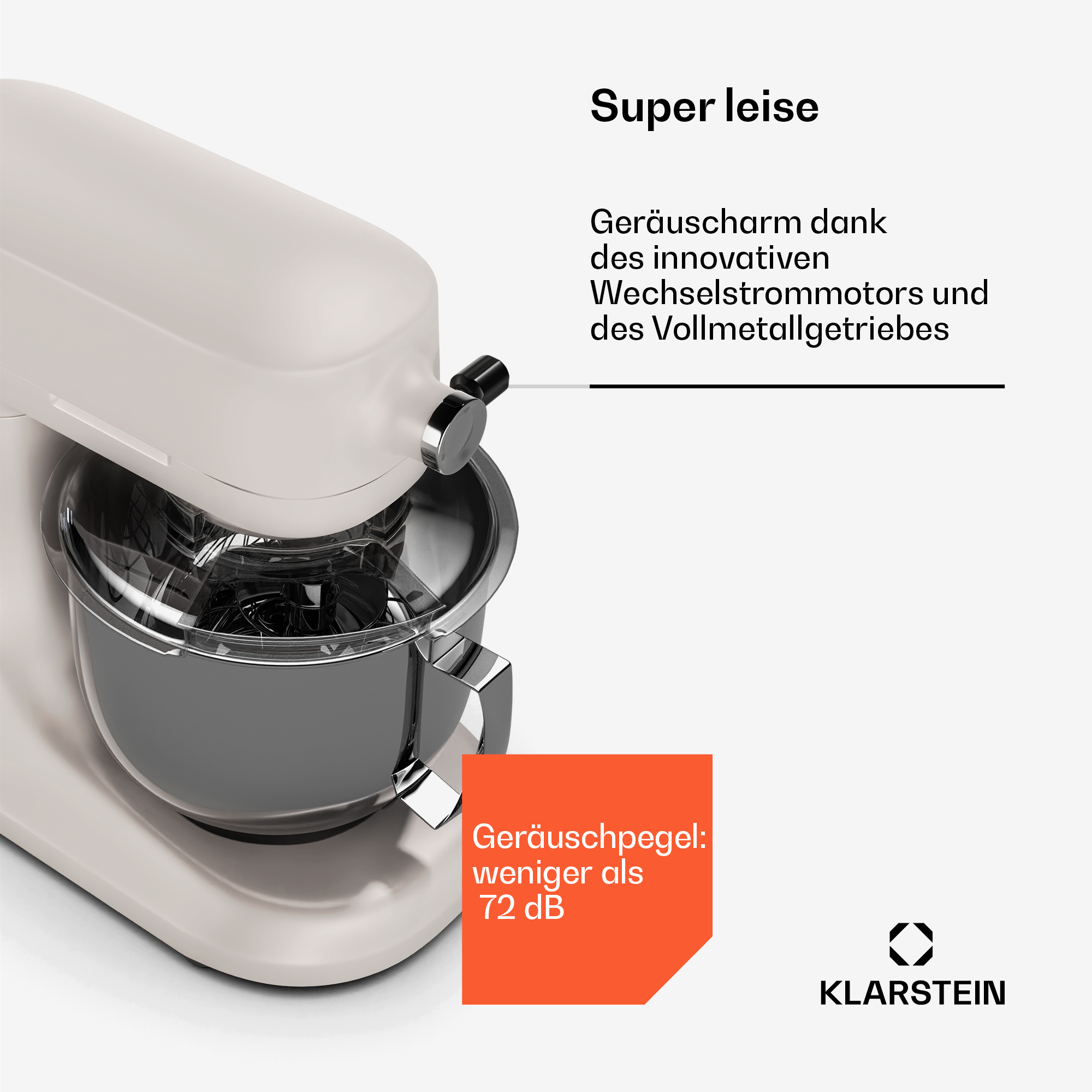 Eine weiße Küchenmaschine mit einer Edelstahlschüssel. Ein orangefarbenes Etikett sagt: Geräuschpegel: weniger als 72 dB.
