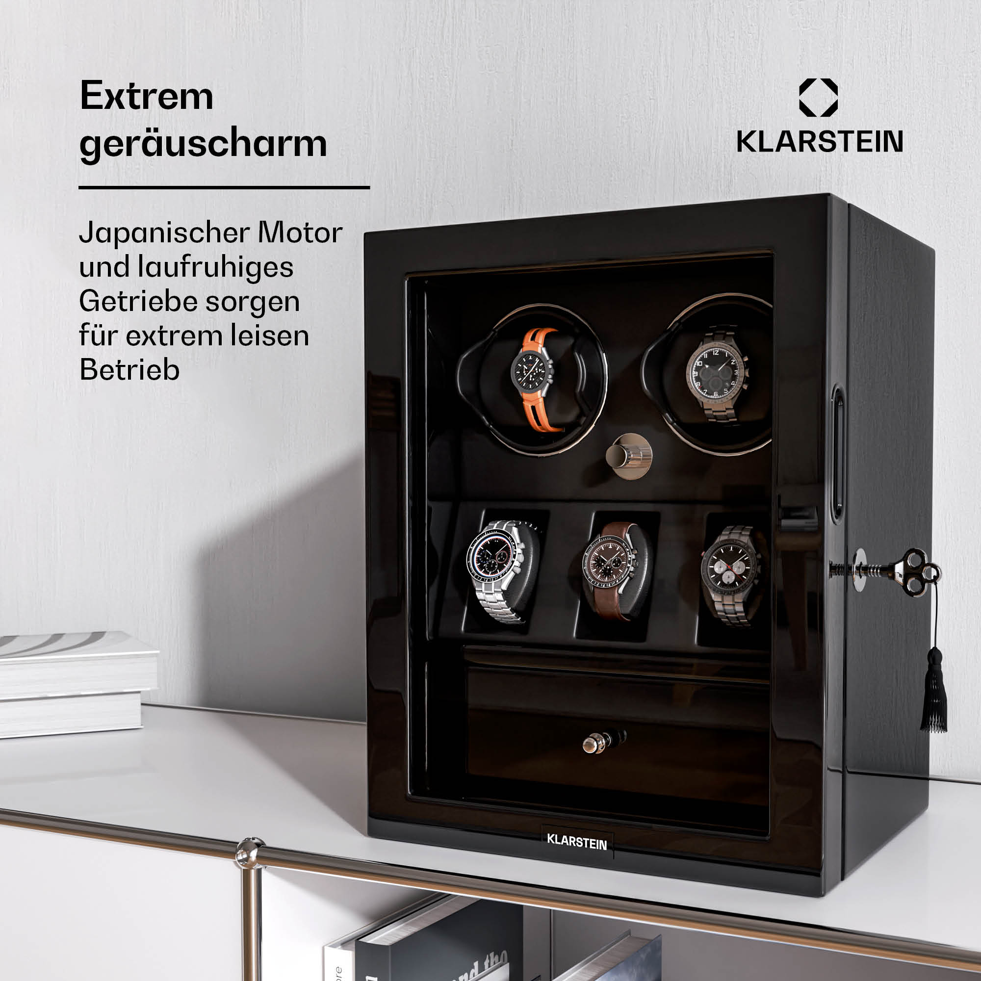 Ein schwarzer Elektroheizer mit Digitalanzeige. Ein Telefon und eine Fernbedienung liegen daneben.