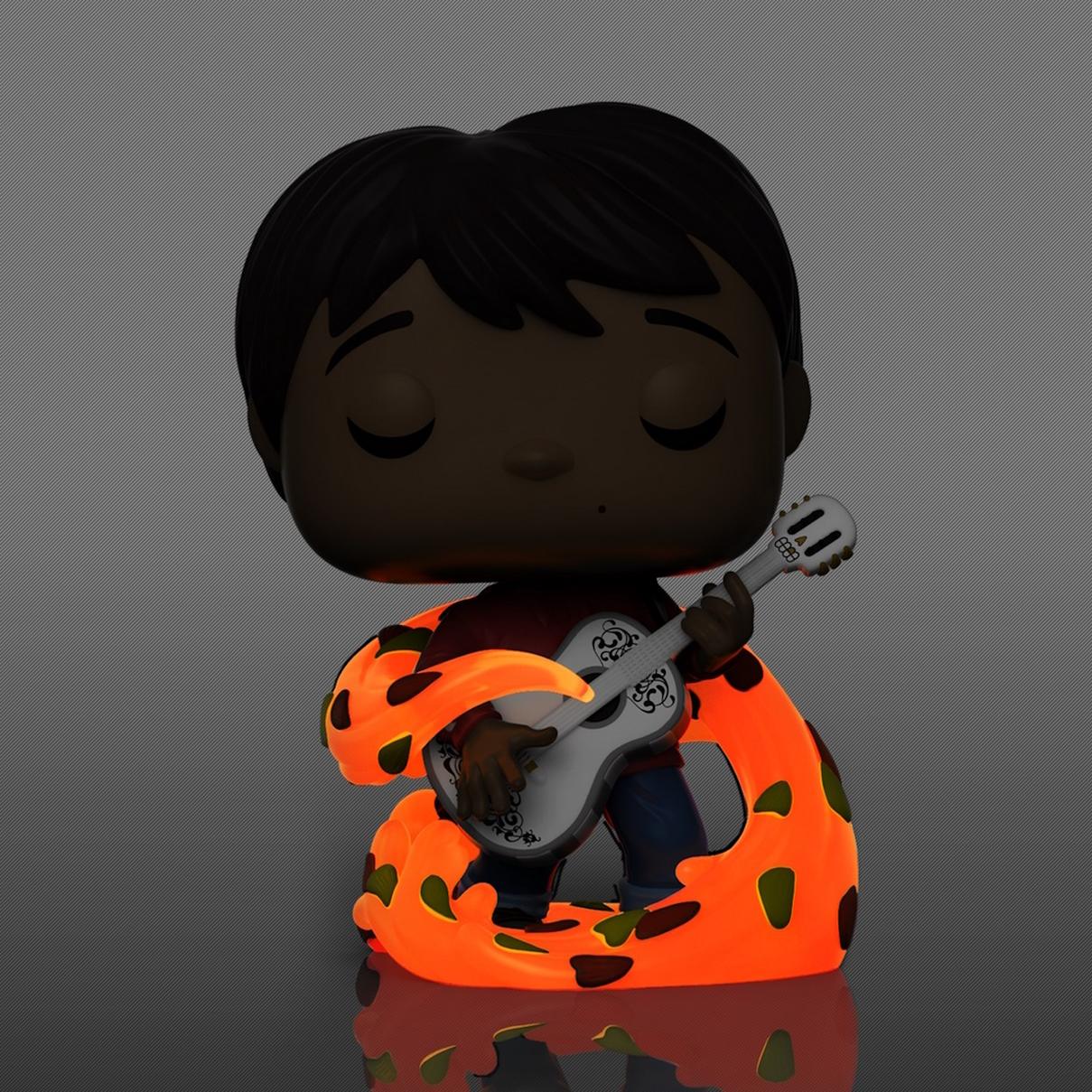Una figura Funko Pop de un niño de dibujos animados sosteniendo una guitarra blanca, con una base naranja brillante.