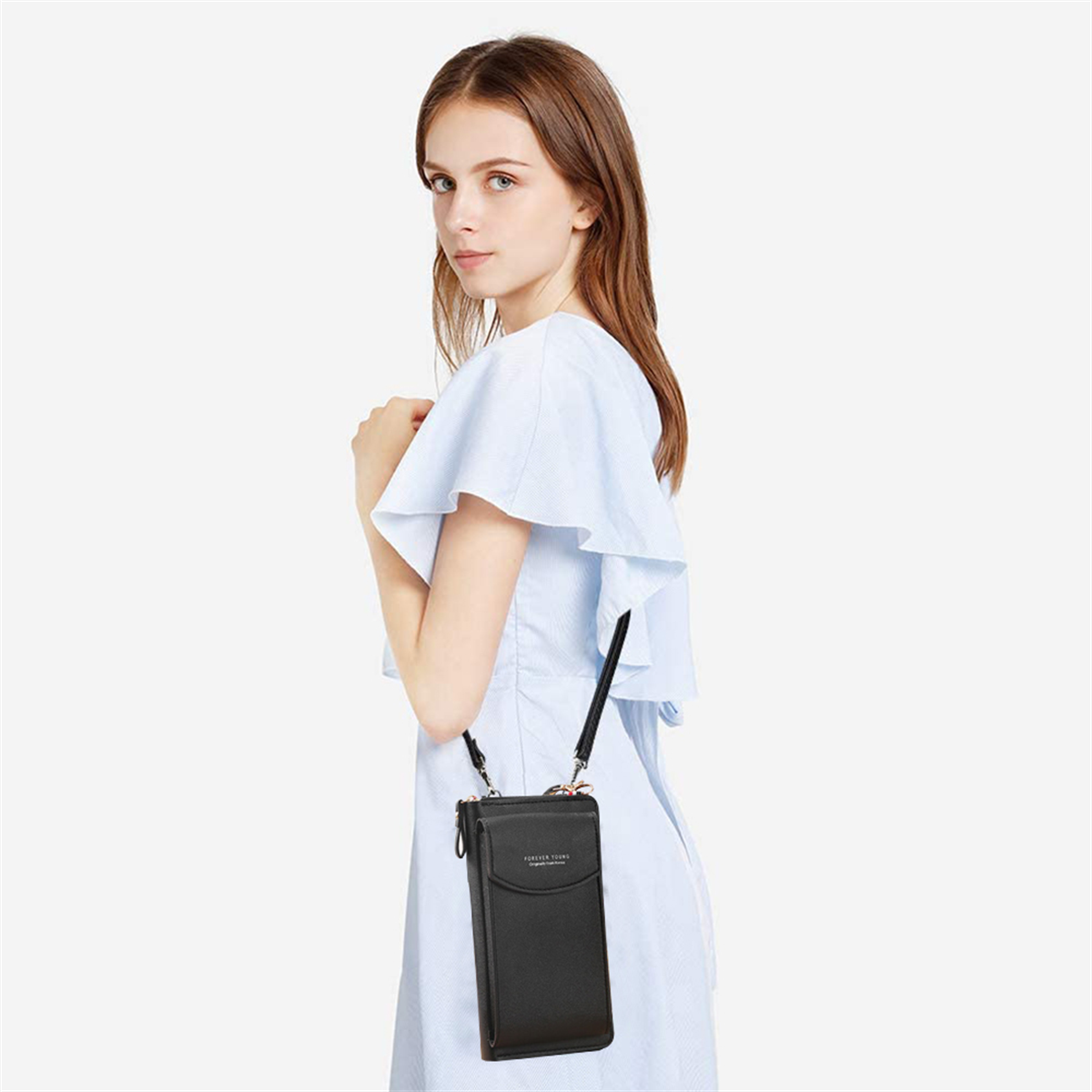 Eine Frau, die eine kleine schwarze Umhängetasche trägt, in einem hellblauen Kleid.