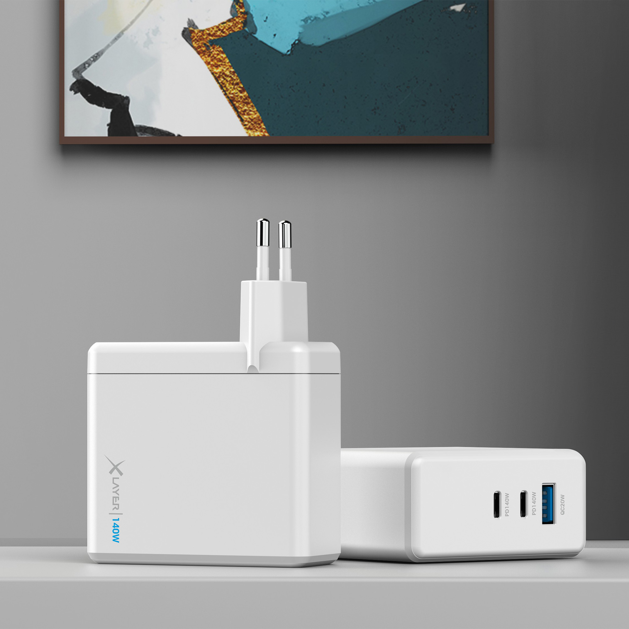 Zwei weiße Ladegeräte mit Stecker. Der Hintergrund ist ein Schreibtisch mit einem Gemälde an der Wand.