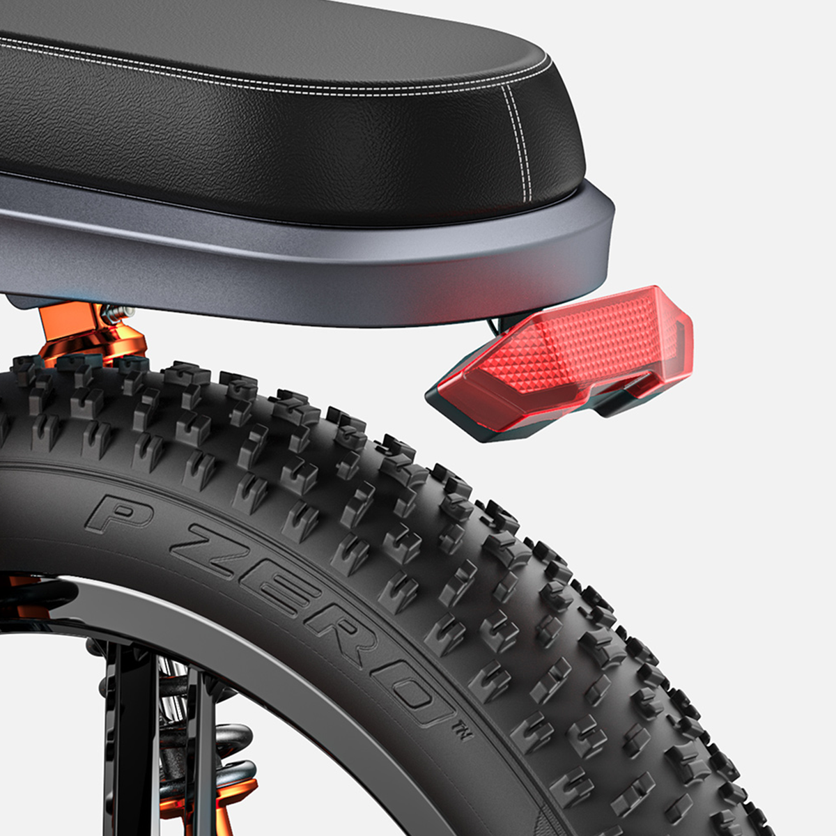 Zbliżenie opony rowerowej i czerwonego odblasku. Opona jest gruba i czarna.