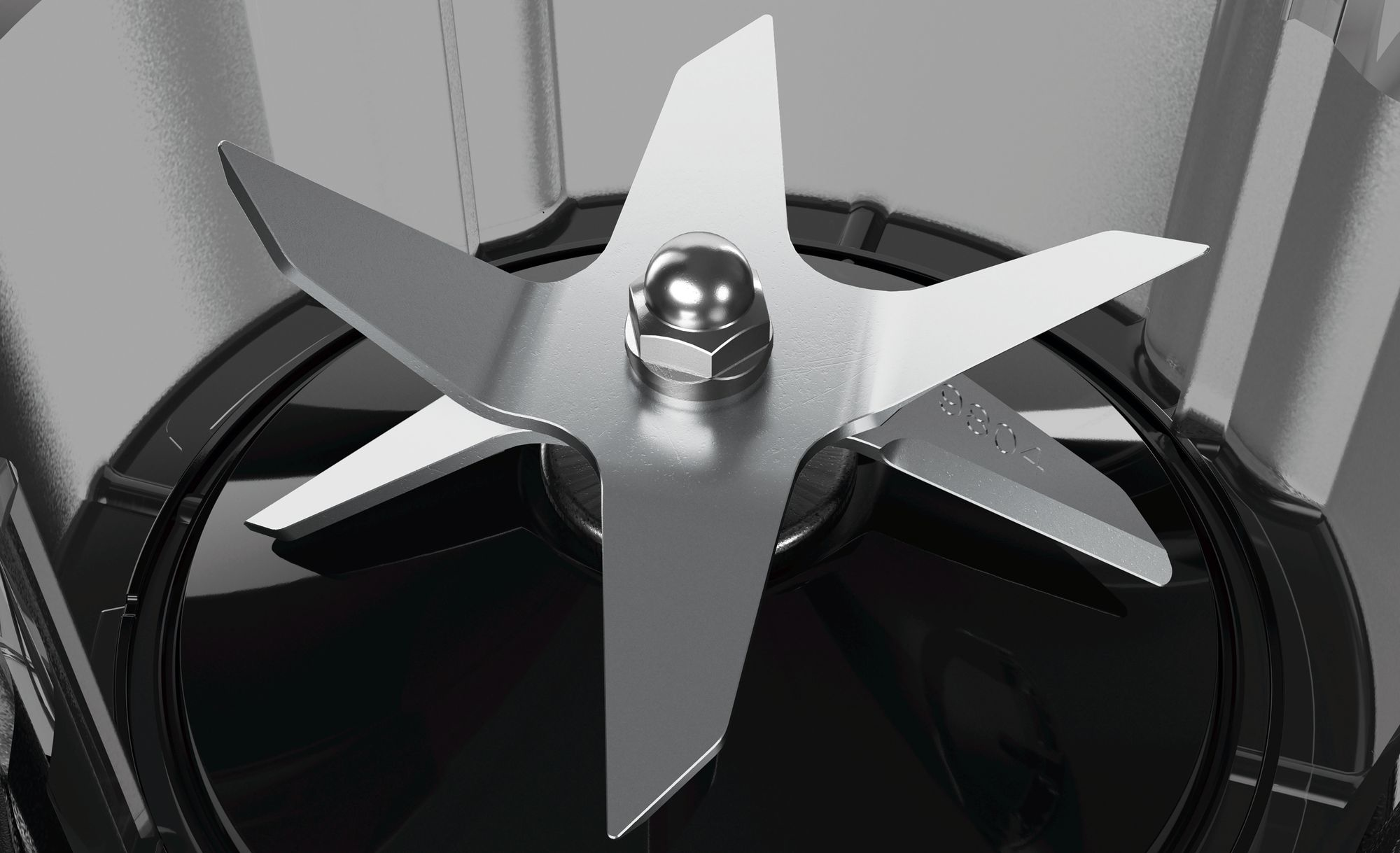 Zbliżenie ostrzy blendera. Cztery ostrza ze stali nierdzewnej na czarnej podstawie. Srebrna nakrętka.