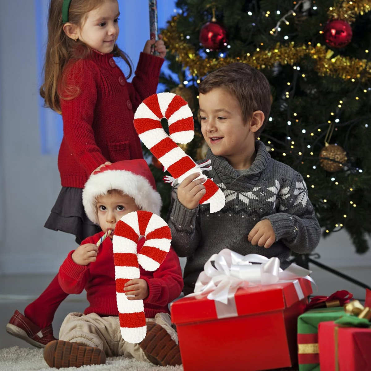 Kinder mit Zuckerstangen und einem geschmückten Weihnachtsbaum.