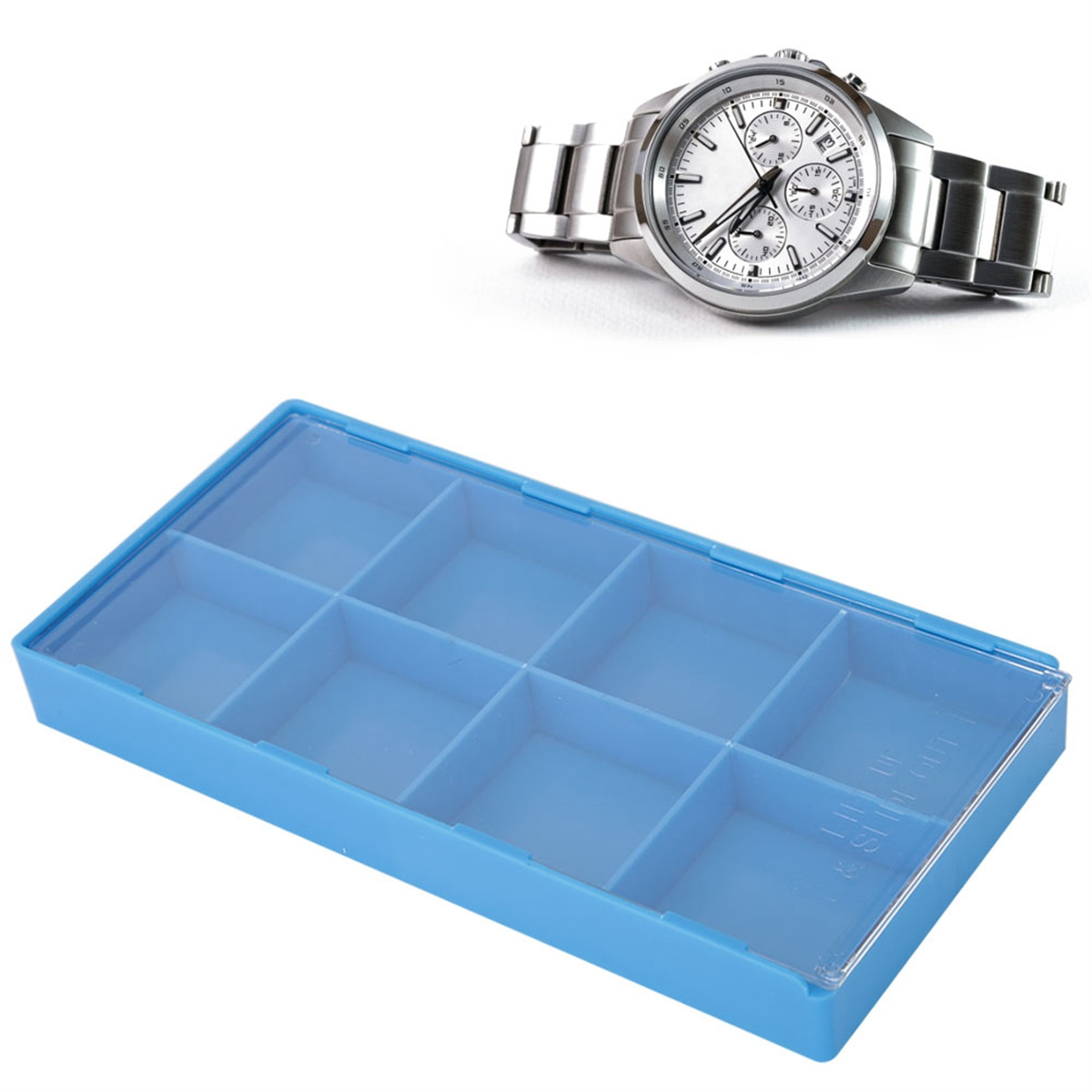 Eine silberne Uhr und eine hellblaue Plastikbox mit zehn Fächern liegen auf weißem Untergrund.