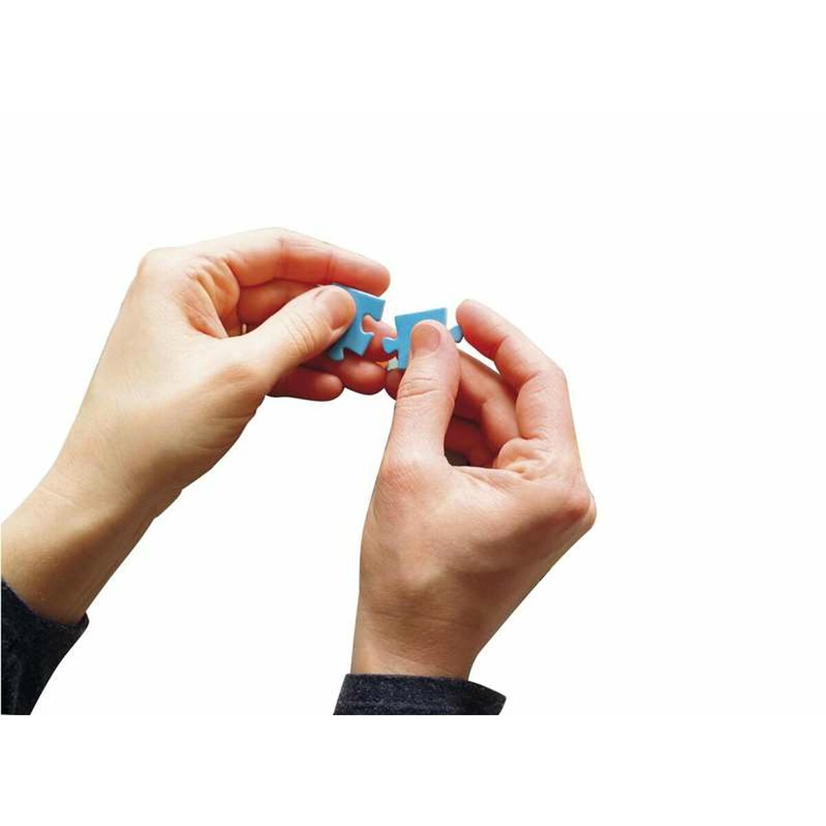 Dwie ręce trzymające dwa niebieskie elementy układanki, gotowe do połączenia.