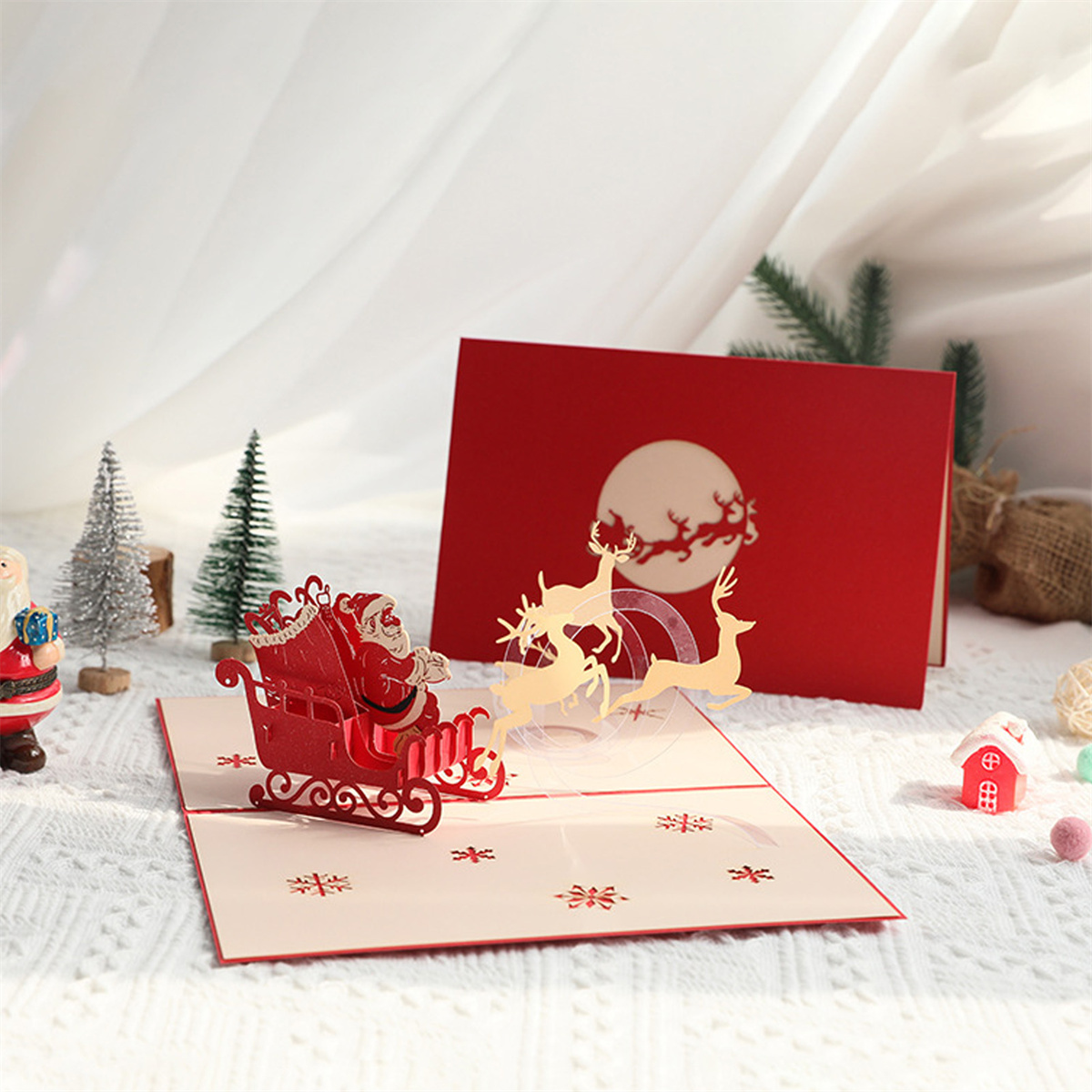 Eine Weihnachtskarte mit einer Szene mit Weihnachtsmann und Rentieren wird mit weißem Hintergrund angezeigt.