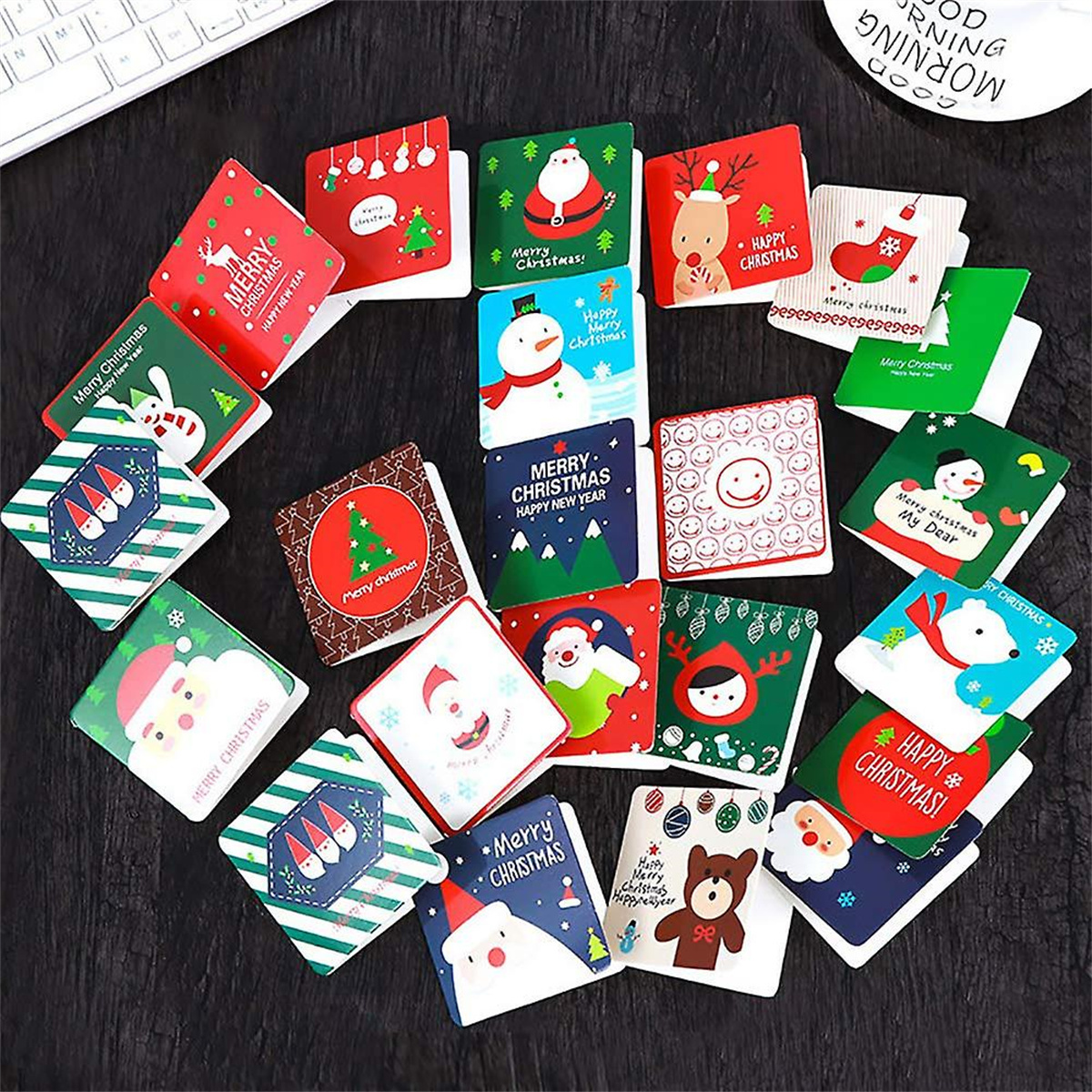 Weihnachtliche Geschenkanhänger mit verschiedenen festlichen Designs, angeordnet auf dunkler Oberfläche.