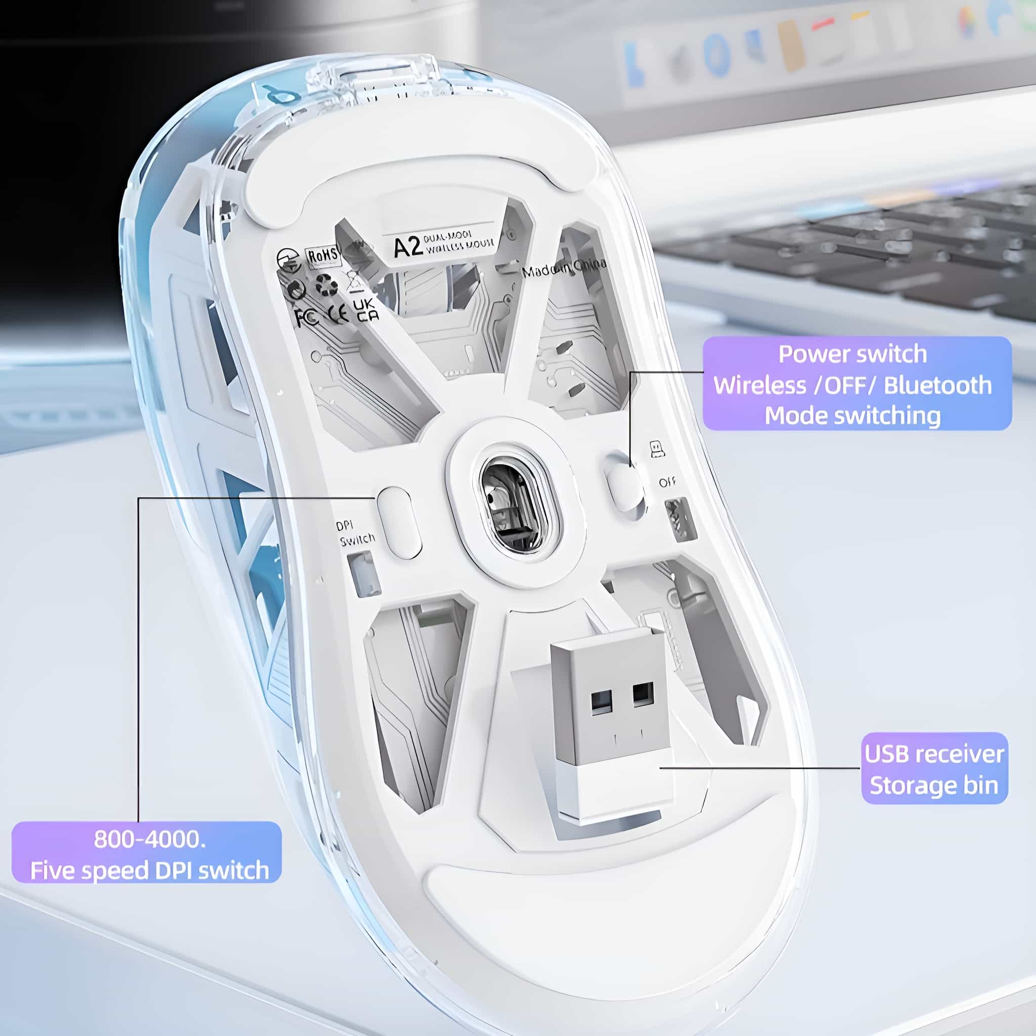 Transparente kabellose Mausbasis. Zeigt interne Komponenten und einen USB-Empfänger. Im Hintergrund ein Laptop.
