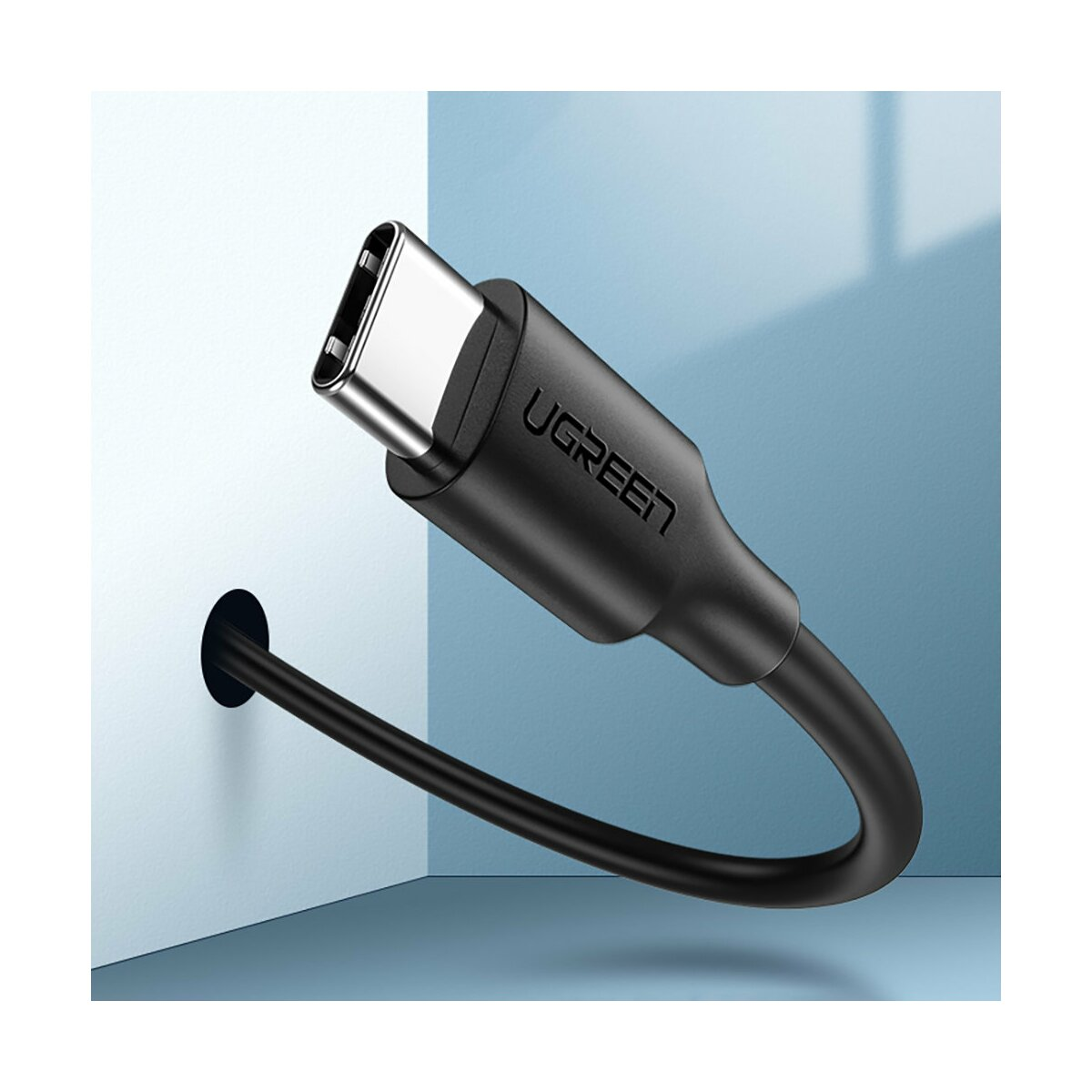 Schwarzes USB-C-Kabel an Wand angeschlossen, weißer und blauer Hintergrund.