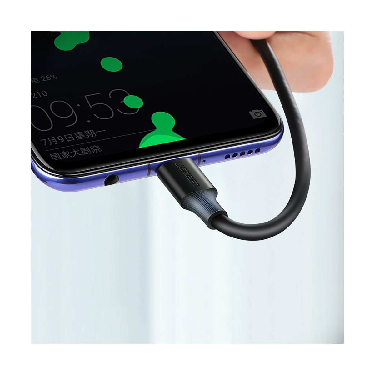 Schwarzes Ladekabel, das in ein Smartphone eingesteckt ist. Marke UGREEN. Weißer Hintergrund.