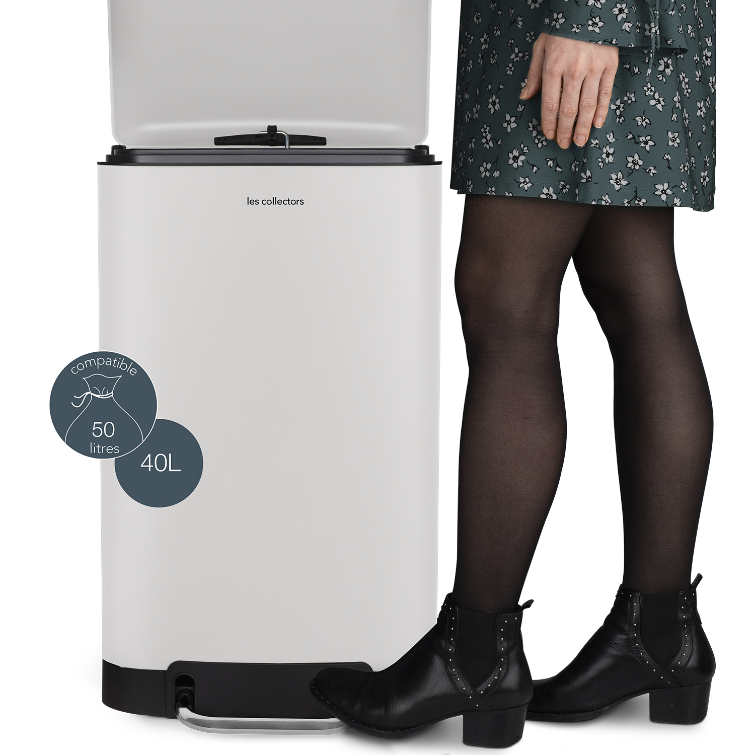 Ein weißer Mülleimer mit einer Frau daneben, die ein Kleid und Stiefel trägt.