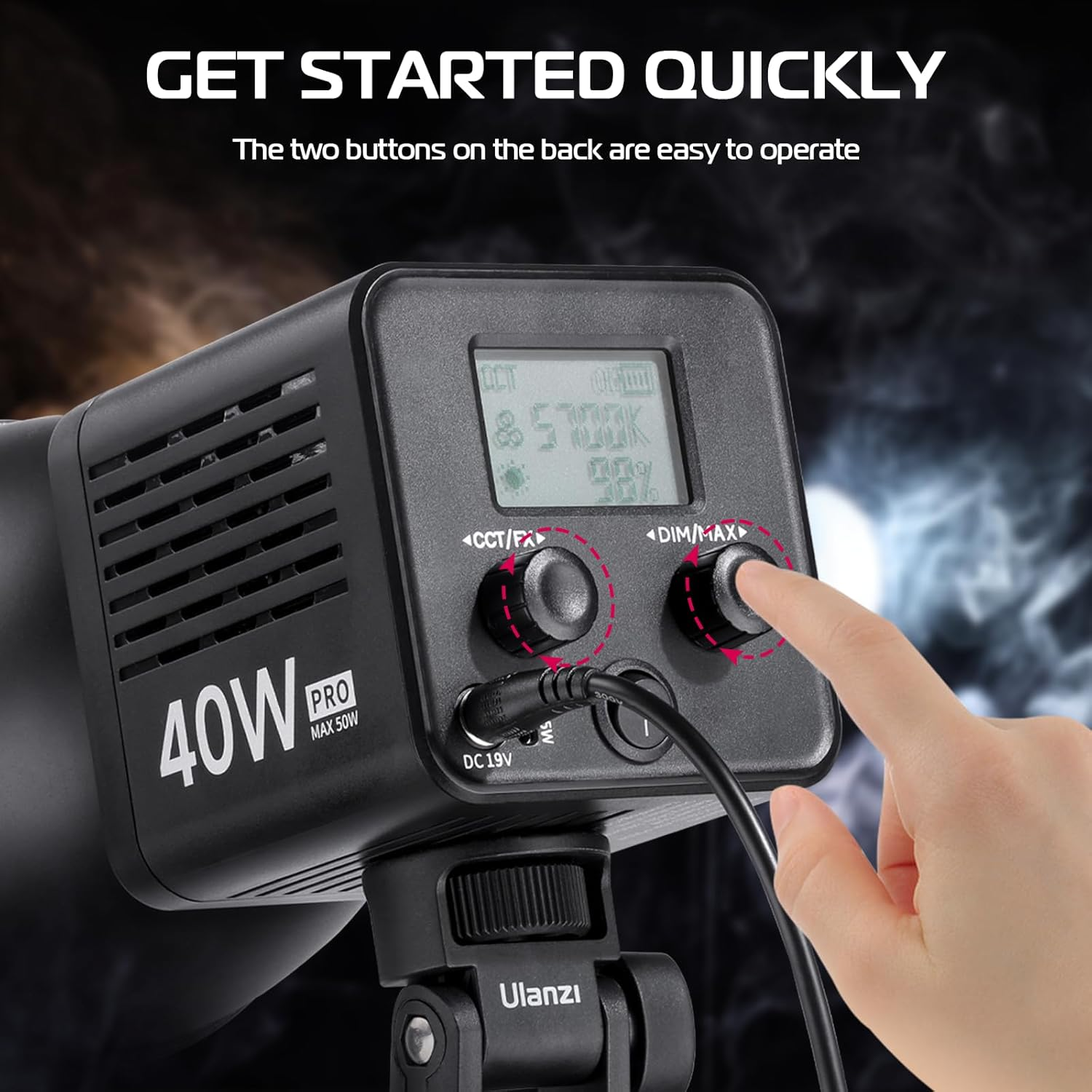 Czarne urządzenie z przyciskami i ekranem. Ręka naciska przycisk po prawej stronie.