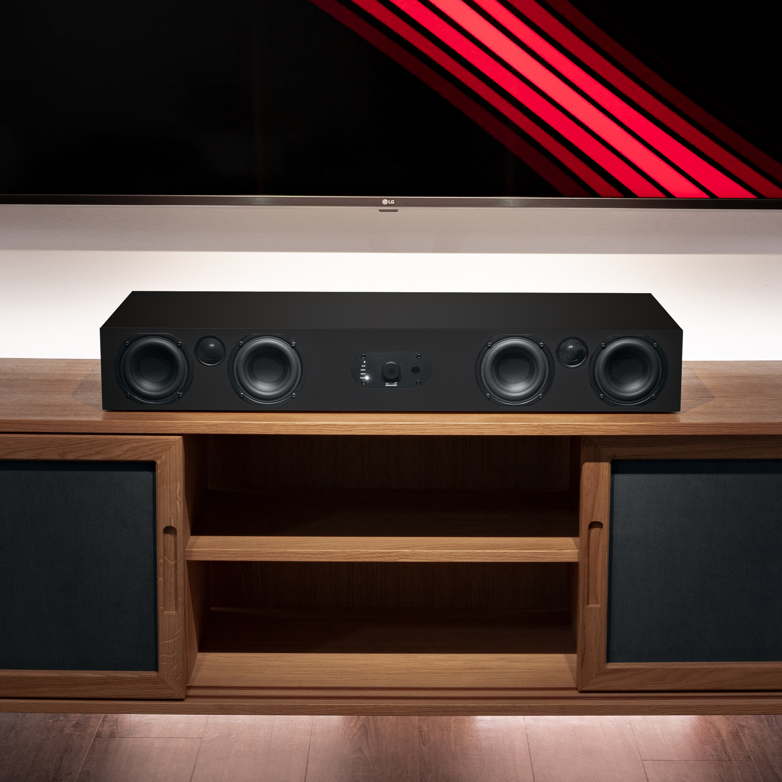 Schwarze Soundbar auf Holzschrank, darüber Fernseher mit roter Akzentbeleuchtung.