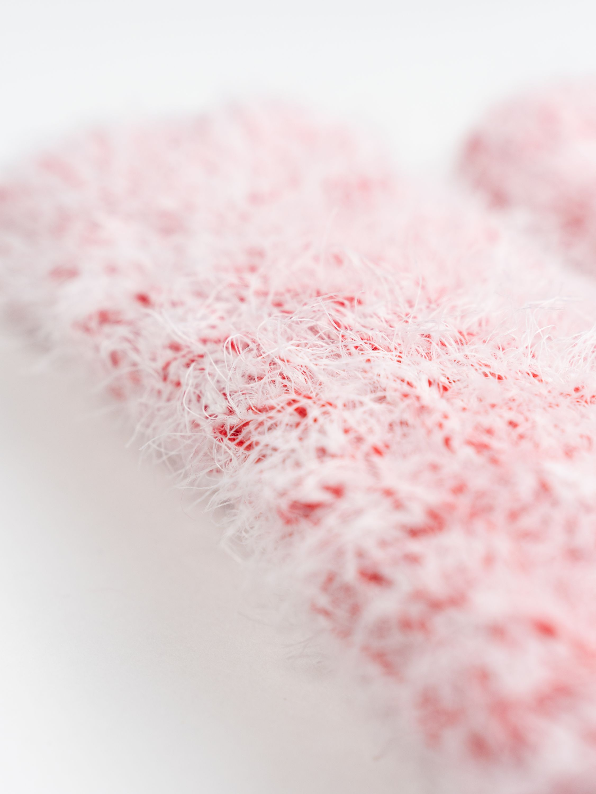 Nahaufnahme von rotem und weißem, fuzzy Material. Die Textur ist weich und flauschig.