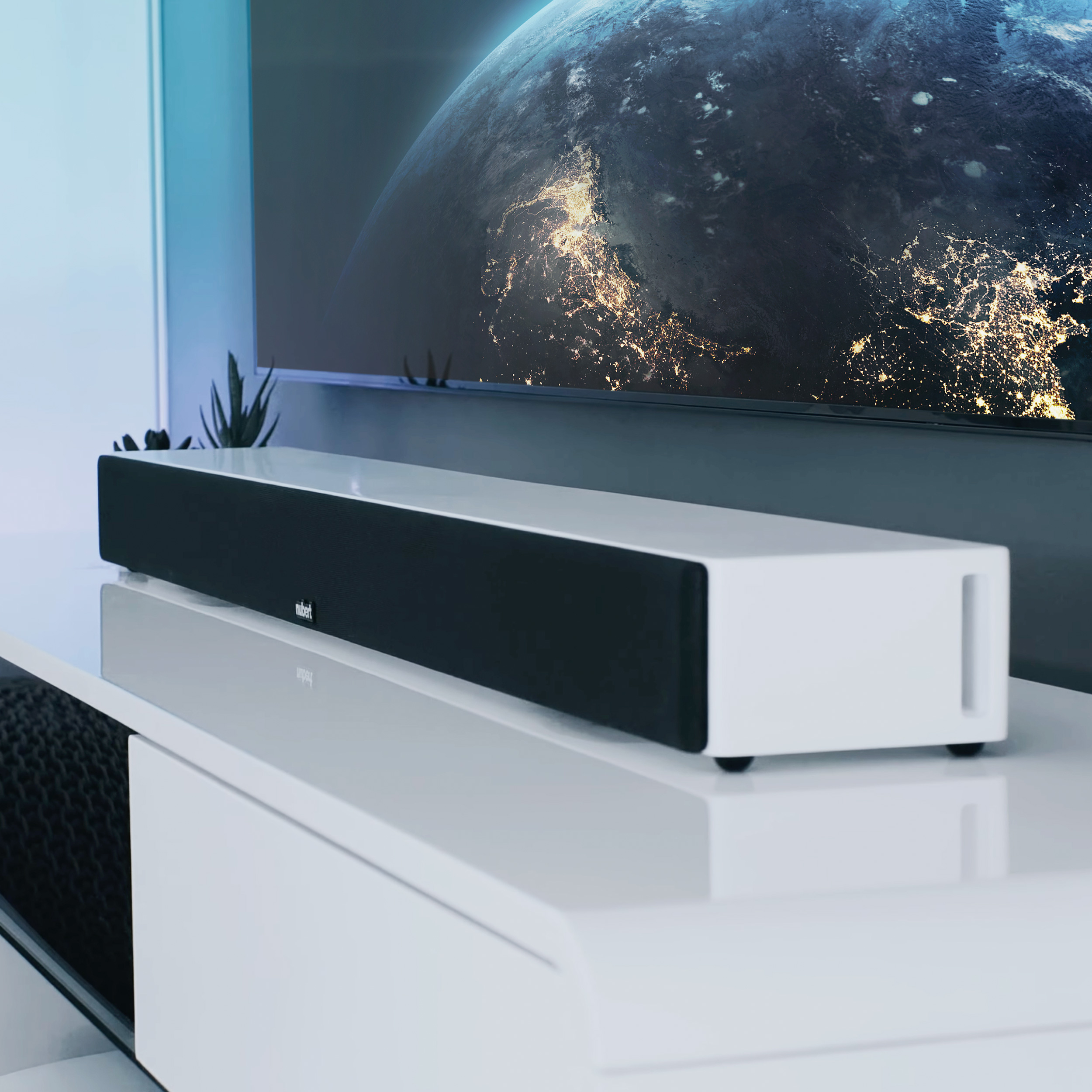 Eine weiße Soundbar auf einem weißen Schrank. Ein Fernseher zeigt ein Weltraumbild.