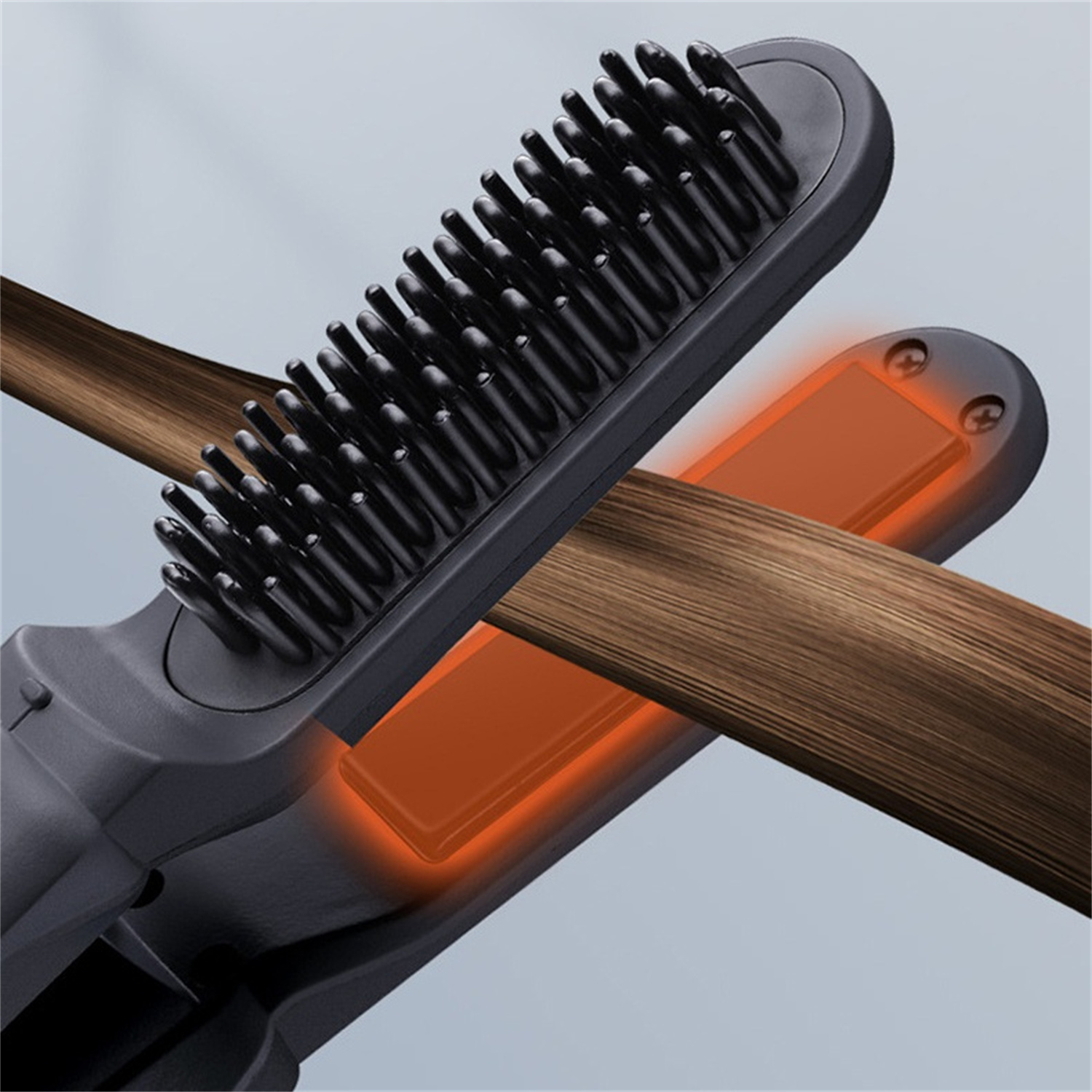 Eine Haarglättungsbürste, mit zu glättendem Haar. Die Bürste hat schwarze Borsten und eine orange Heizplatte.