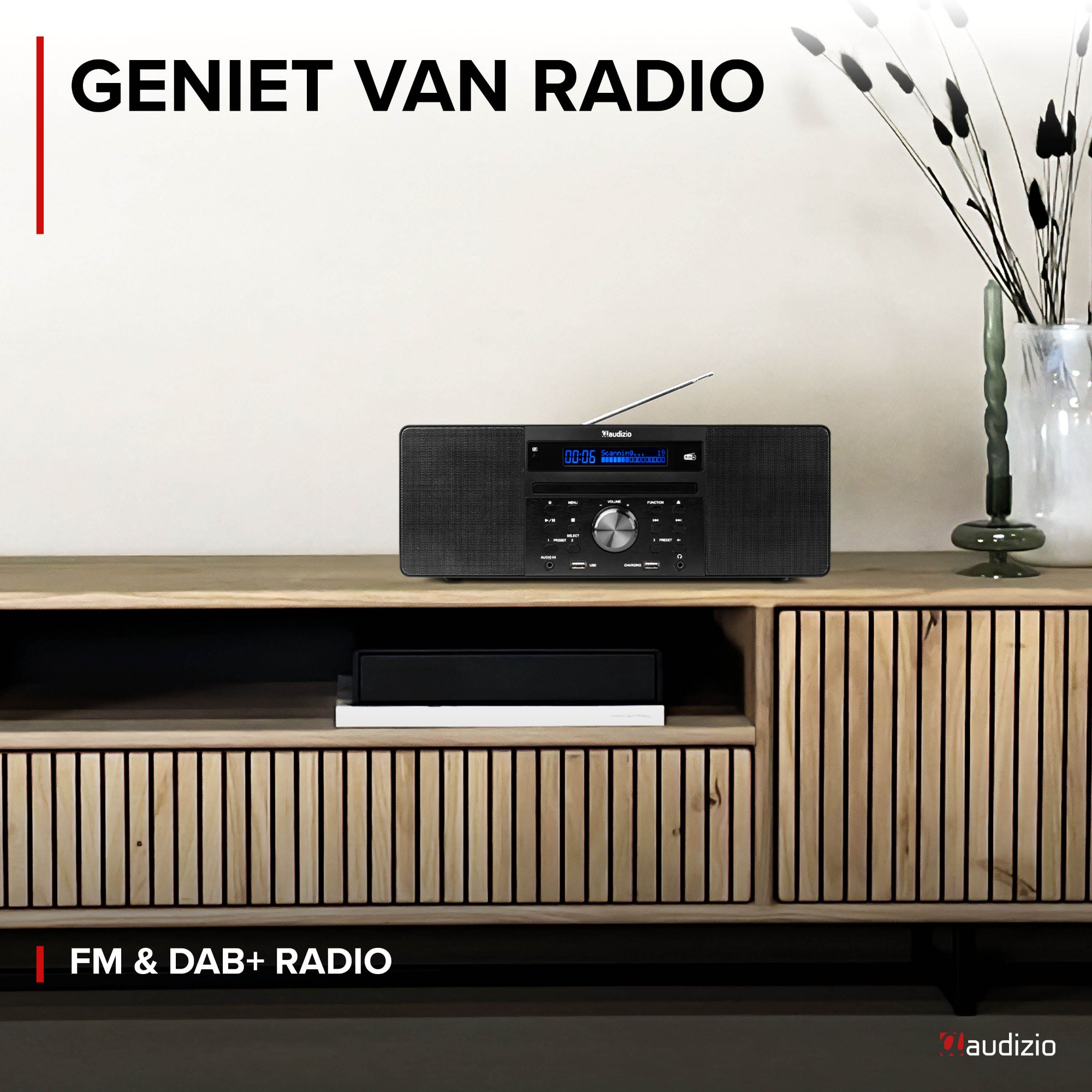 Schwarzes Radio auf einem Holzregal, mit dem Text 'GENIET VAN RADIO'.