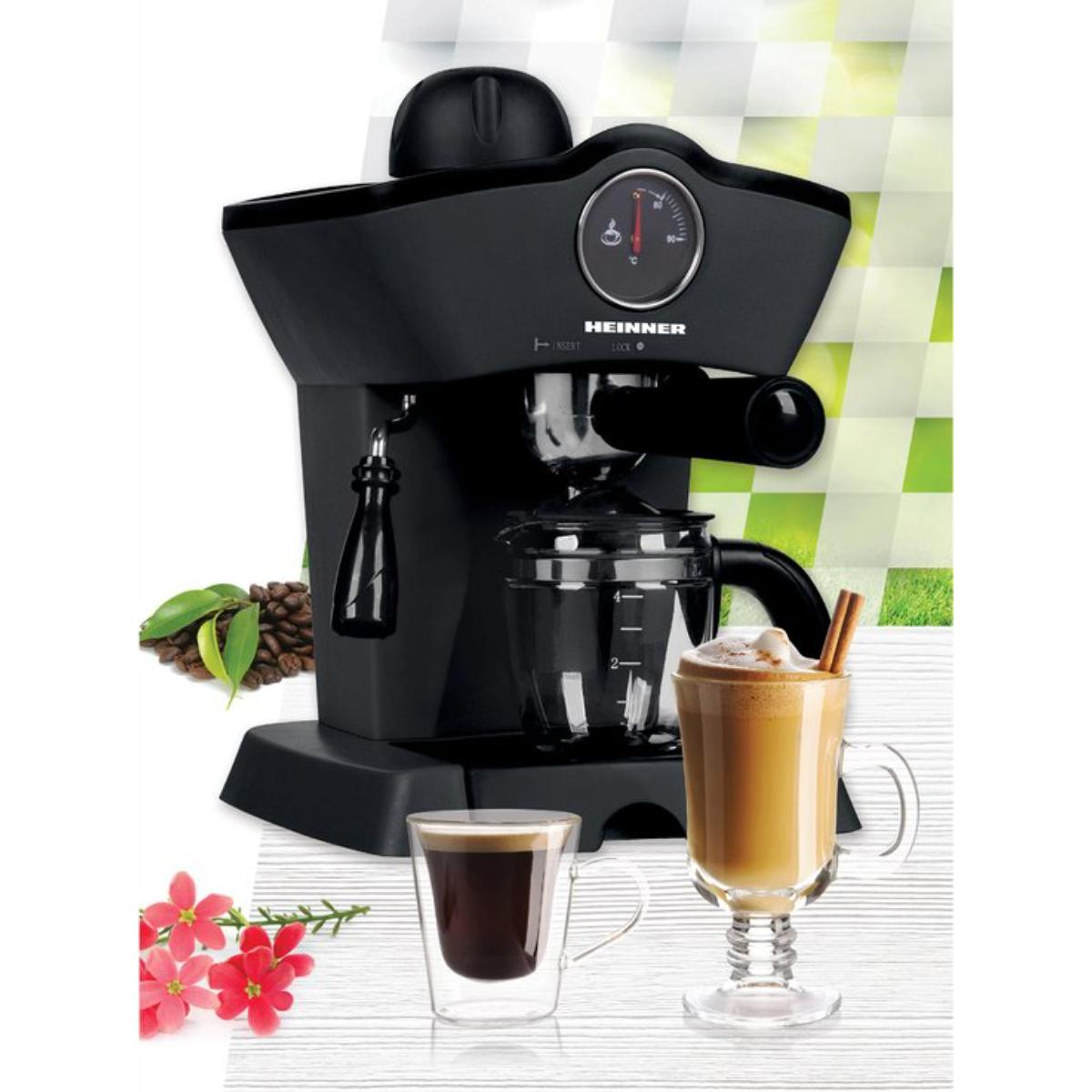 Machine à expresso noire avec café et latte. Des fleurs rouges et des grains de café sont également présents.