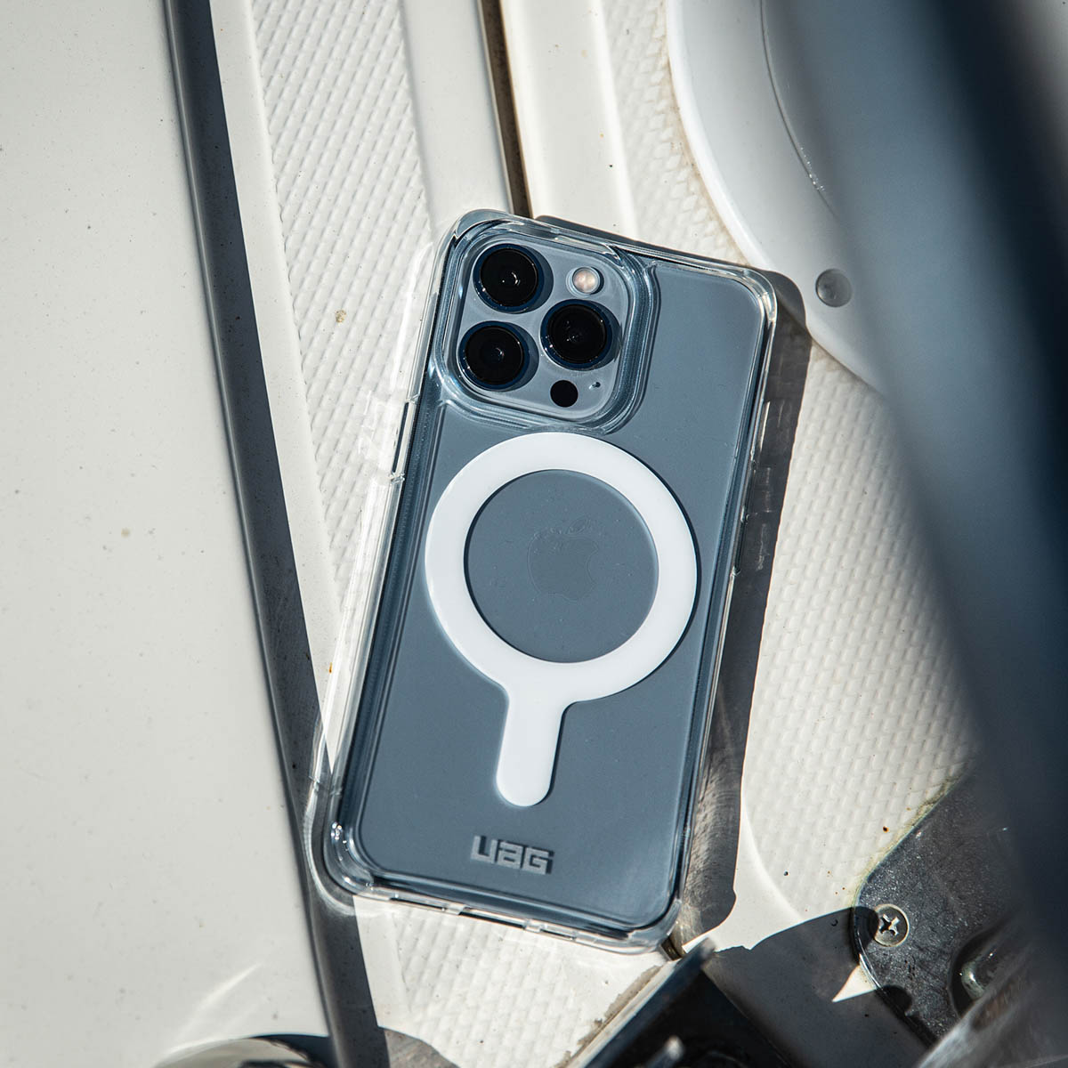 Een telefoon met een doorzichtige hoes op een wit oppervlak. De hoes heeft een witte cirkel.